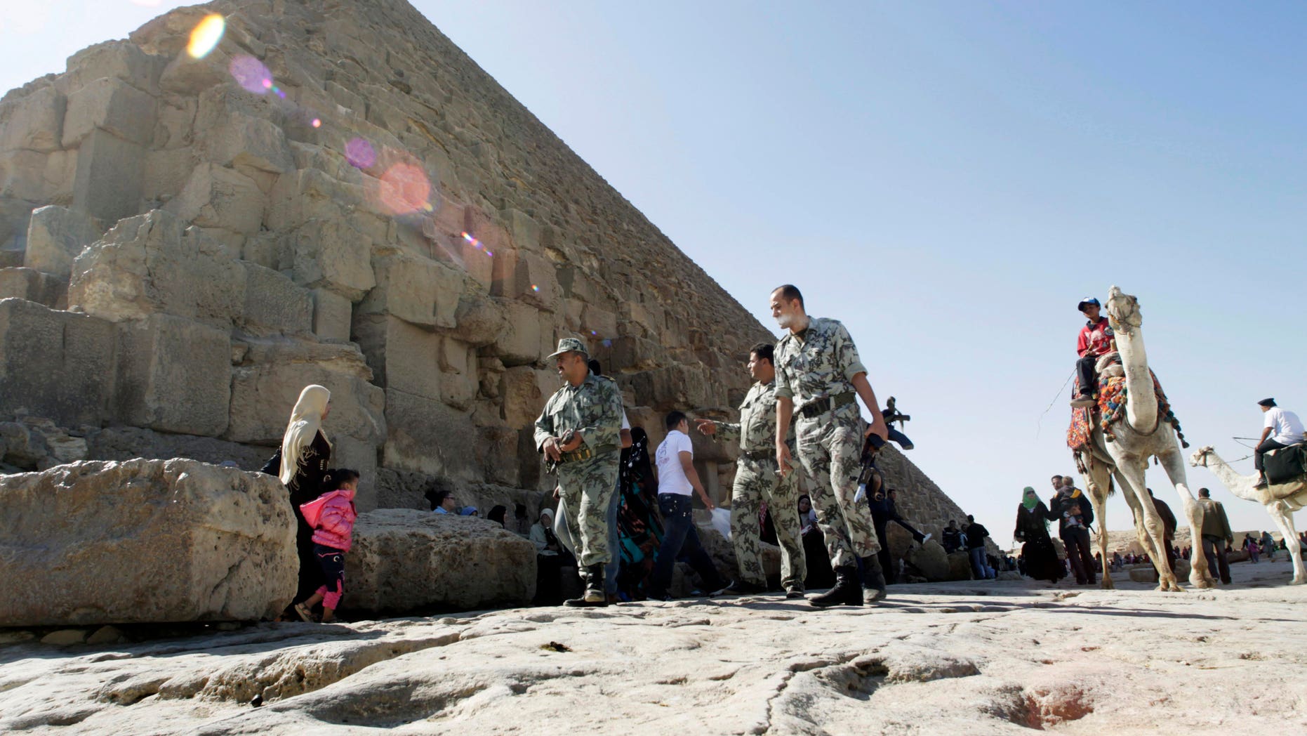 Nov. 11, 2011: Egyptian soldiers walk at the base the pyramid of Khufu, largest of the Giza Pyramids in Cairo, Egypt.