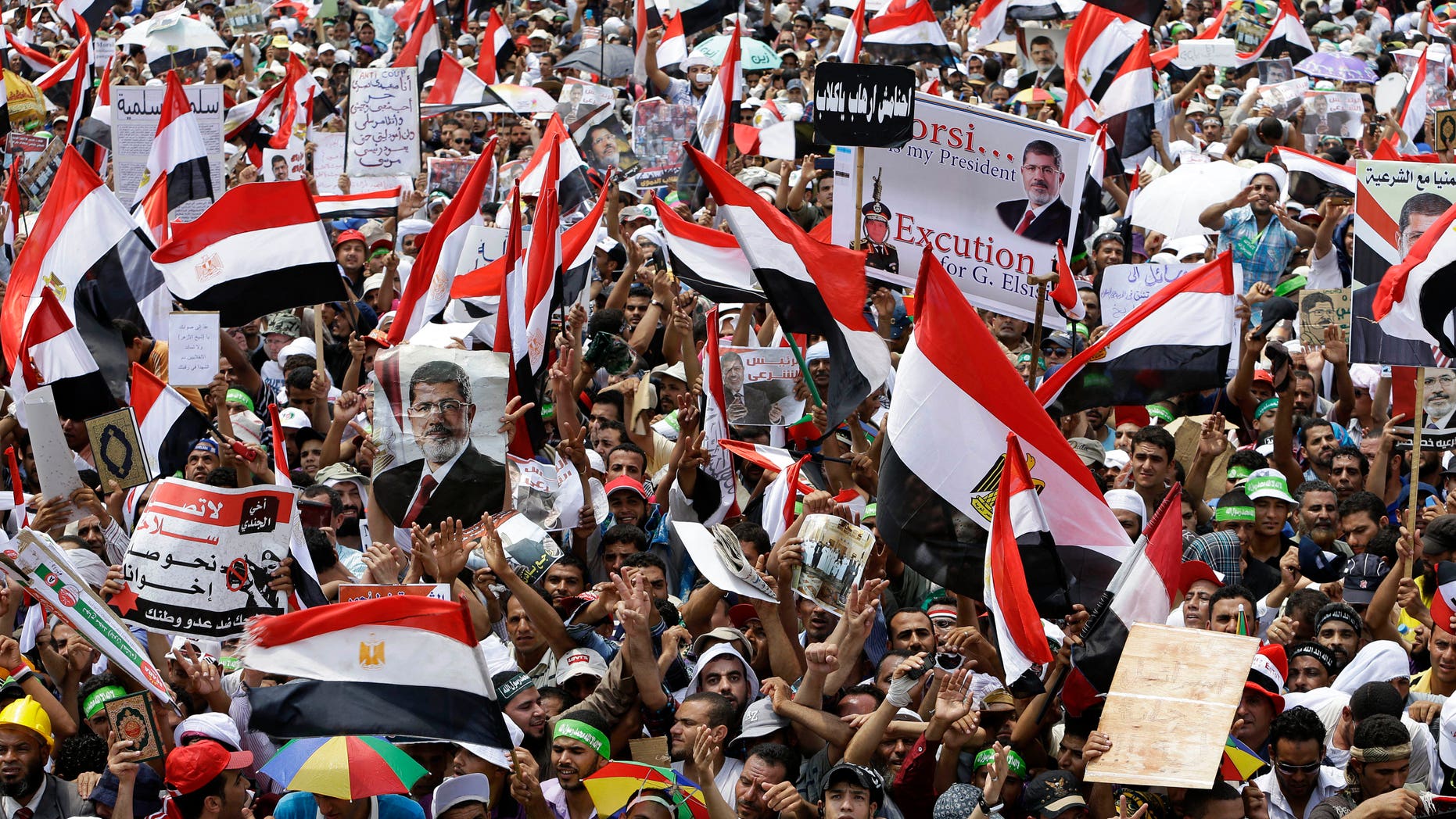July 19, 2013 - Supporters of Egypt's ousted President Mohammed Morsi wave their national flags during a demonstration where protesters have installed their camp and hold their daily rally, at Nasr City, Cairo, Egypt.