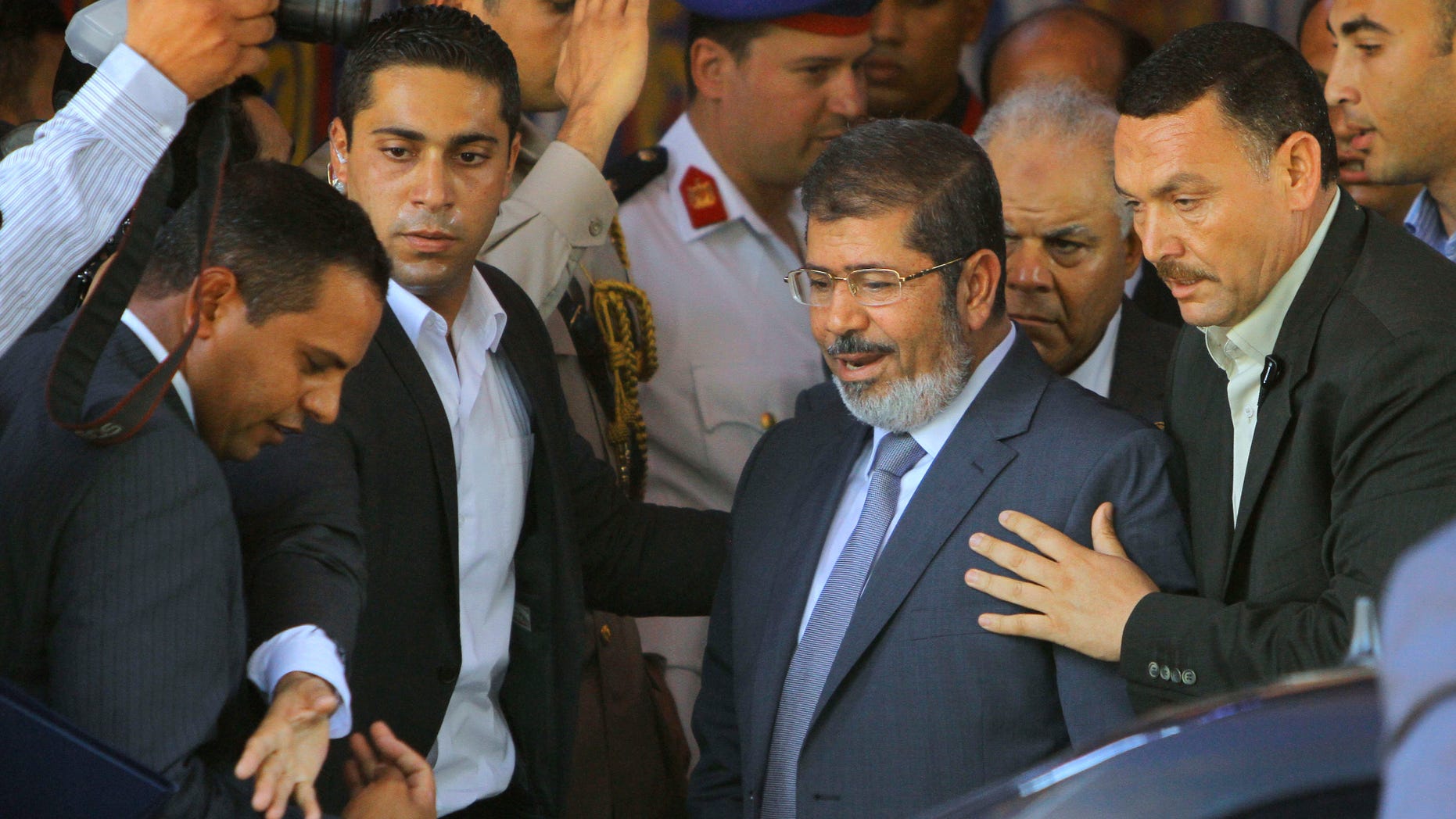 June 29, 2012: Egypt's President-elect Mohammed Morsi is guarded by presidential security as he leaves Friday prayers at Al-Azhar mosque, in Cairo, Egypt.