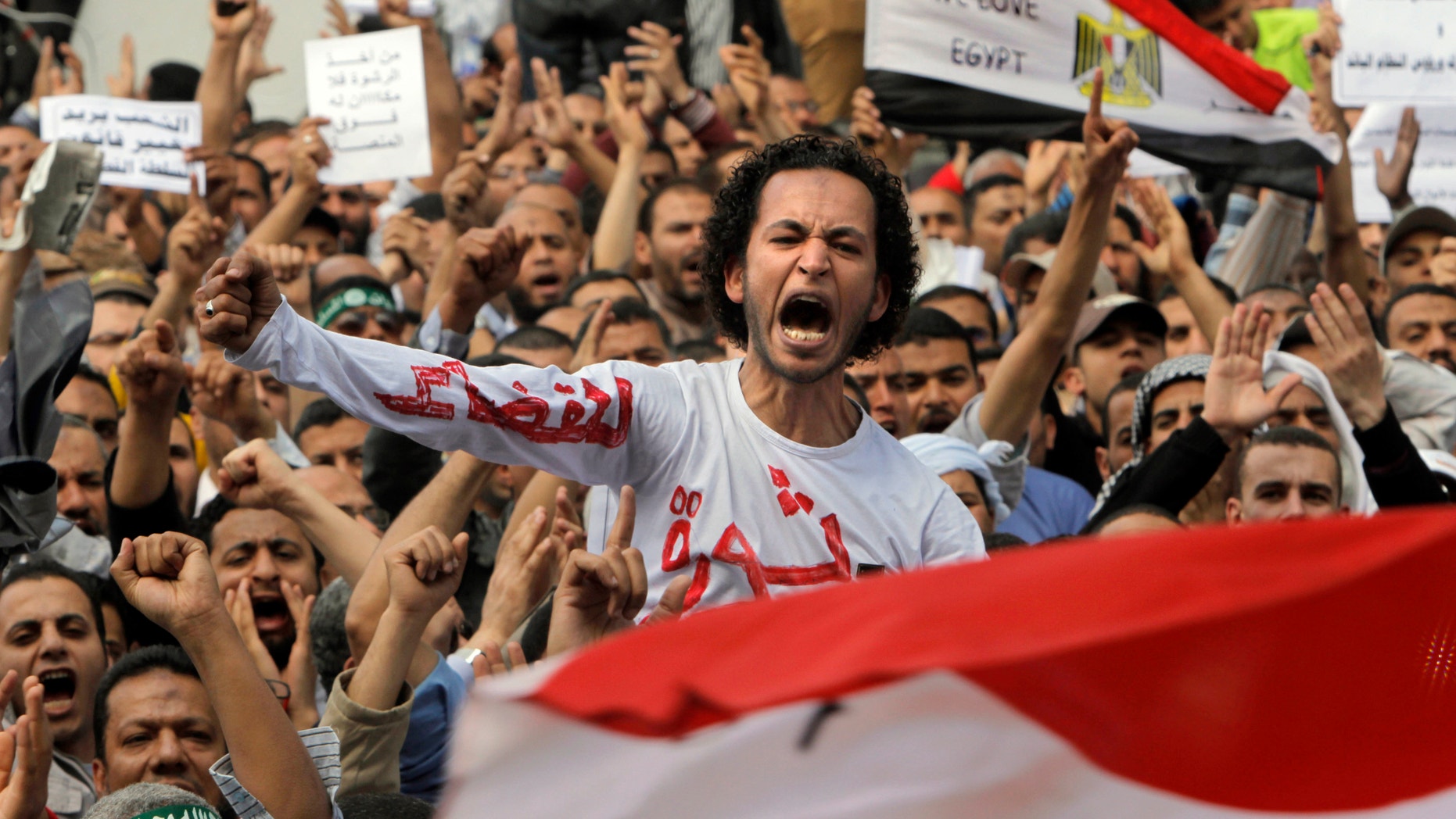 April 19, 2013 - Egyptian Muslim Brotherhood members shout slogans during a protest in front of the Supreme Judicial Council in Cairo, Egypt. Arabic on the T-shirt reads, "clean judiciary."