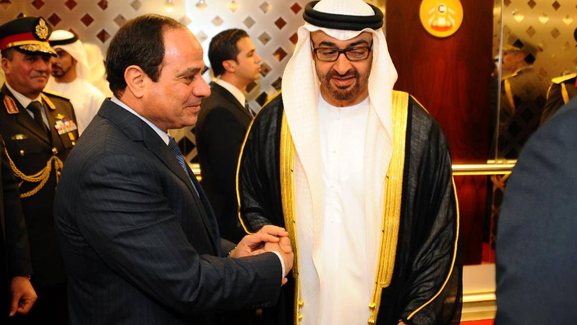 In this Saturday, Jan. 17, 2015 photo, Egyptian President Abdel-Fattah el-Sissi, left, shakes hands with Abu Dhabi crown prince, Sheikh Mohammed bin Zayed Al Nahyan, in Abu Dhabi, United Arab Emirates. The first official visit by El-Sissi reflects the strong support the Emirates has given el-Sissi's government since he was elected in June after leading the 2013 military overthrow of Islamist President Mohammed Morsi. (AP Photo/MENA)