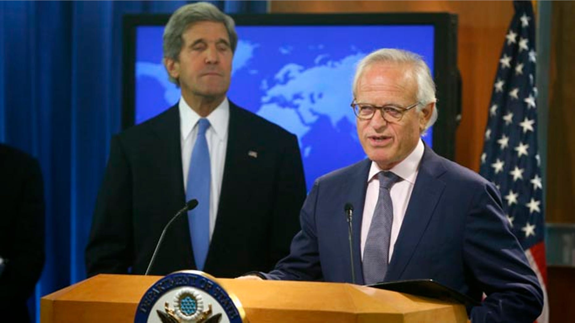 This July 29, 2013 file photo shows Secretary of State John Kerry listening as Martin Indyk speaks at the State Department in Washington.