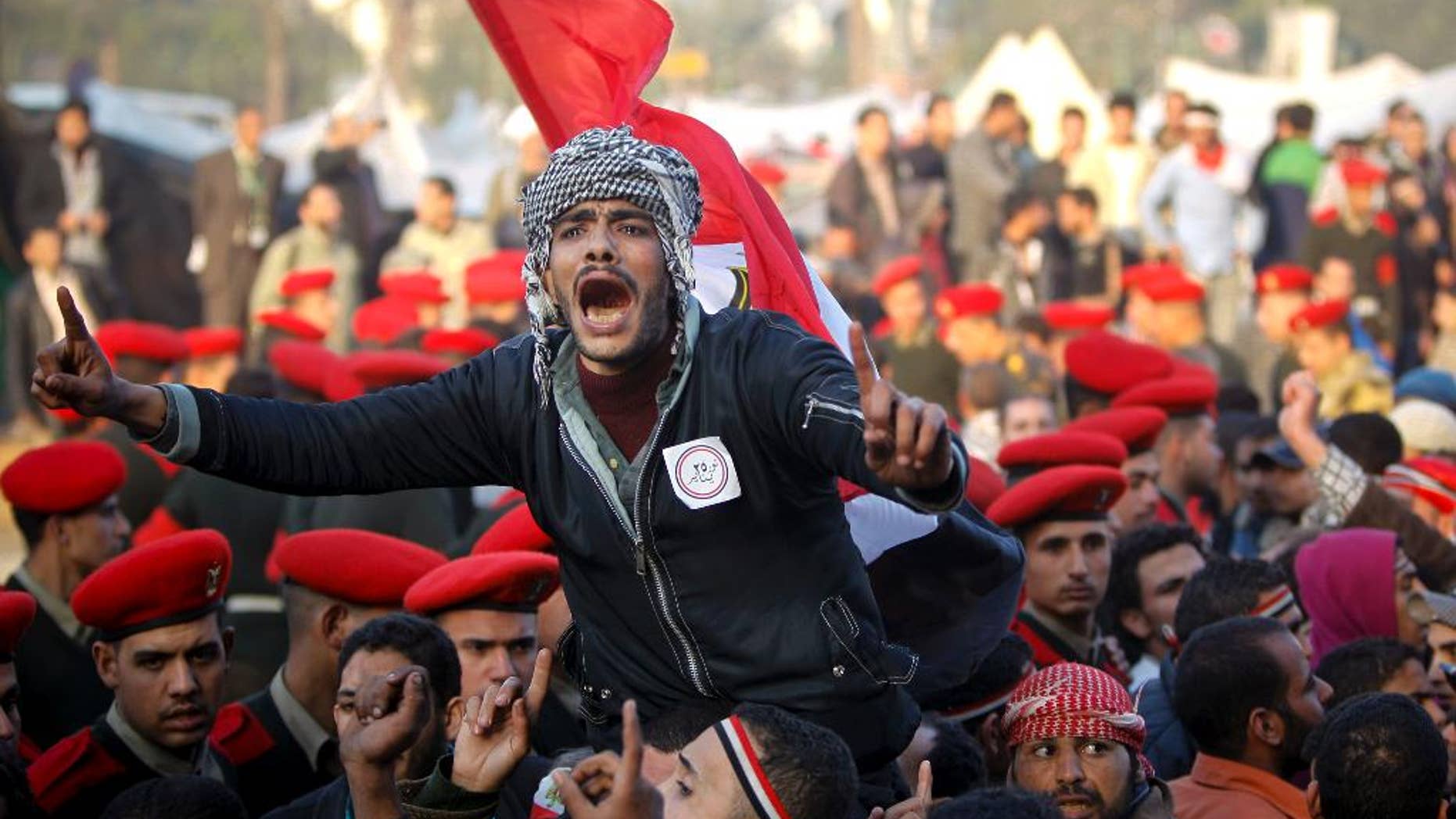 FILE - In this Feb. 13, 2011 file photo, remaining Egyptian protesters shout slogans as they are surrounded by army soldiers trying to lead them away from Tahrir Square in Cairo, Egypt. Within days, a cheering world community was riveted to screens as Egypt's long-submissive people thronged to Cairo's Tahrir Square, braving bullets and refusing to leave until veteran ruler Hosni Mubarak stepped down. (AP Photo/Tara Todras-Whitehill, File)