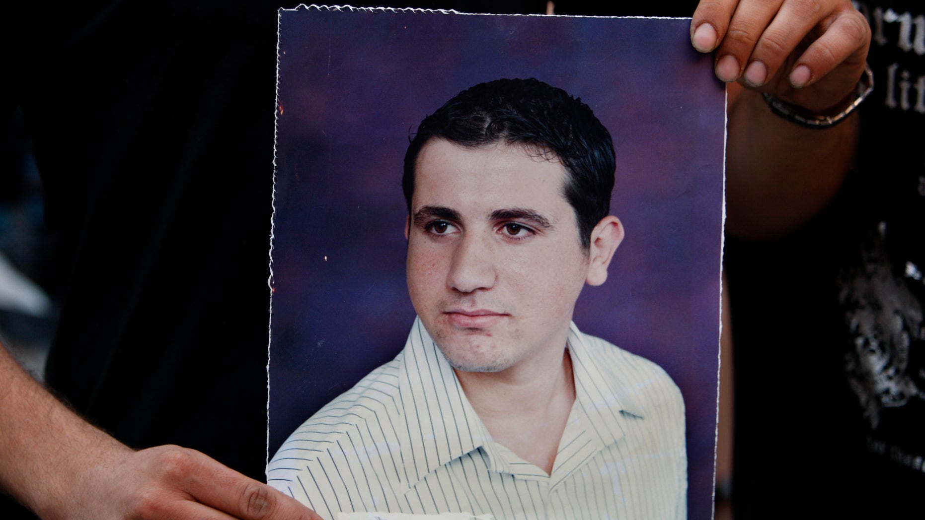 July 16, 2012: A Palestinian Christian holds a poster of Ramez Al-Amash, 25, who was allegedly kidnapped, during a rally for his release, at a Greek Orthodox church in Gaza City.