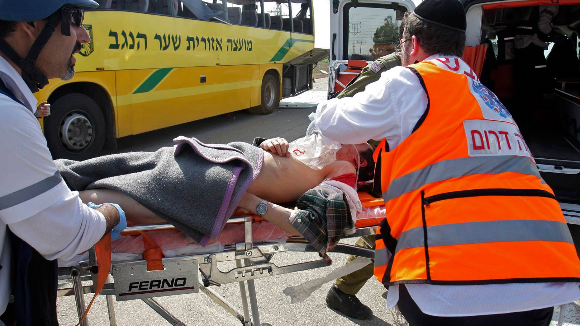 April 7: A wounded Israeli is treated by medics at the site where an Israeli school bus was hit by a mortar shell fired from the Gaza Strip near the border between southern Israel and Gaza Wednesday. A Palestinian mortar shell from the Gaza Strip struck a school bus in southern Israel Thursday, wounding two people, including one child critically, Israeli officials said.