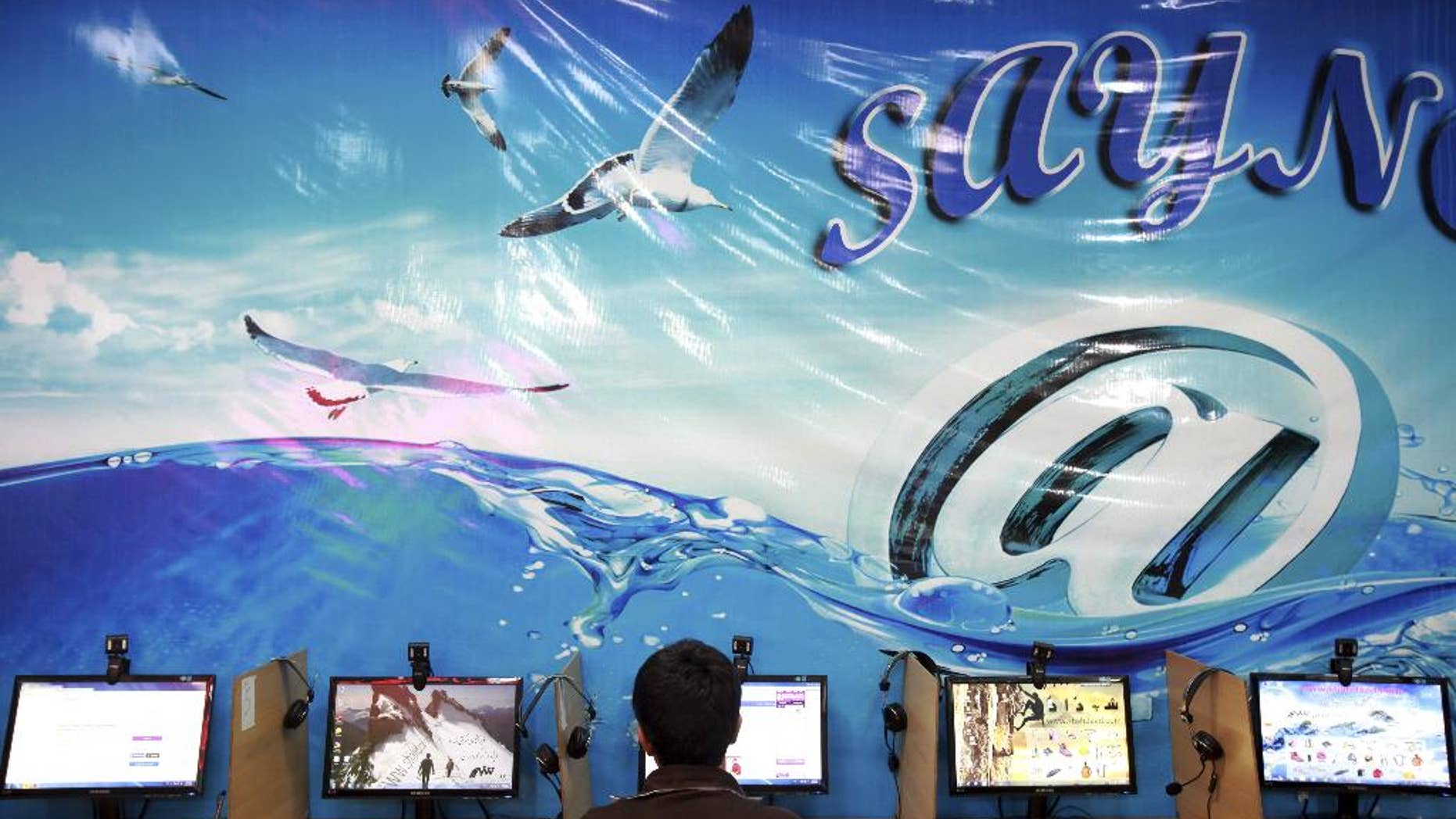 FILE - In this Tuesday, Sept, 17, 2013 file photo, an Iranian man surfs the Internet at a cafe in Tehran, Iran. Iran's official news agency reported on Sunday, July 13, 2014 that eight Facebook page administrators have been handed jail sentences from eight to 21 years. The report by IRNA says the defendants were convicted of plotting against national security, spreading propaganda against the ruling system and insulting officials. It did not identify the defendants or the Facebook pages. (AP Photo/Ebrahim Noroozi, File)