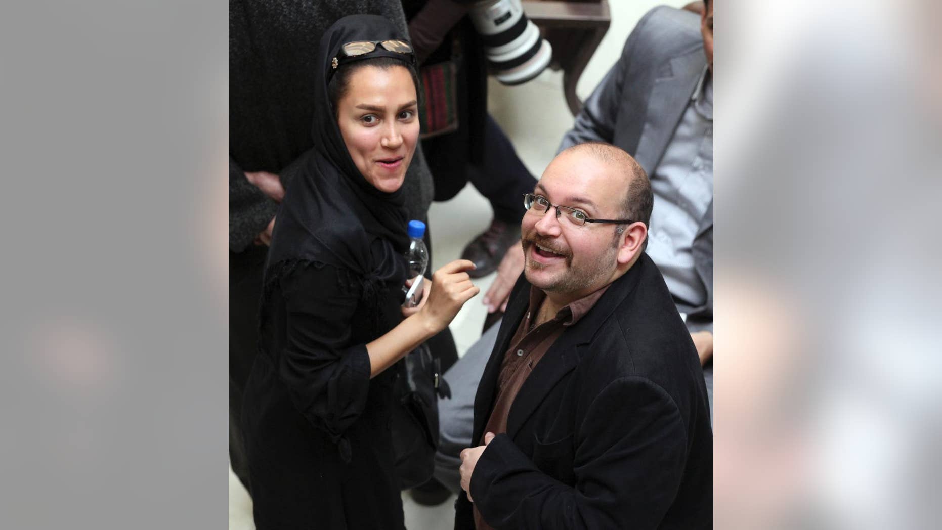 In this photo taken on April 11, 2013, Jason Rezaian, right, an Iranian-American correspondent for the Washington Post, and his wife Yeganeh Salehi, an Iranian correspondent for the Abu Dhabi-based daily newspaper The National, smile as they attend a presidential campaign of President Hassan Rouhani in Tehran, Iran. They have been held in custody for a month since their detention July 2014 in Iran, suggesting a possible struggle between a new guard of moderates pushing for greater freedom and the old hard-line establishment. (AP Photo/Vahid Salemi)
