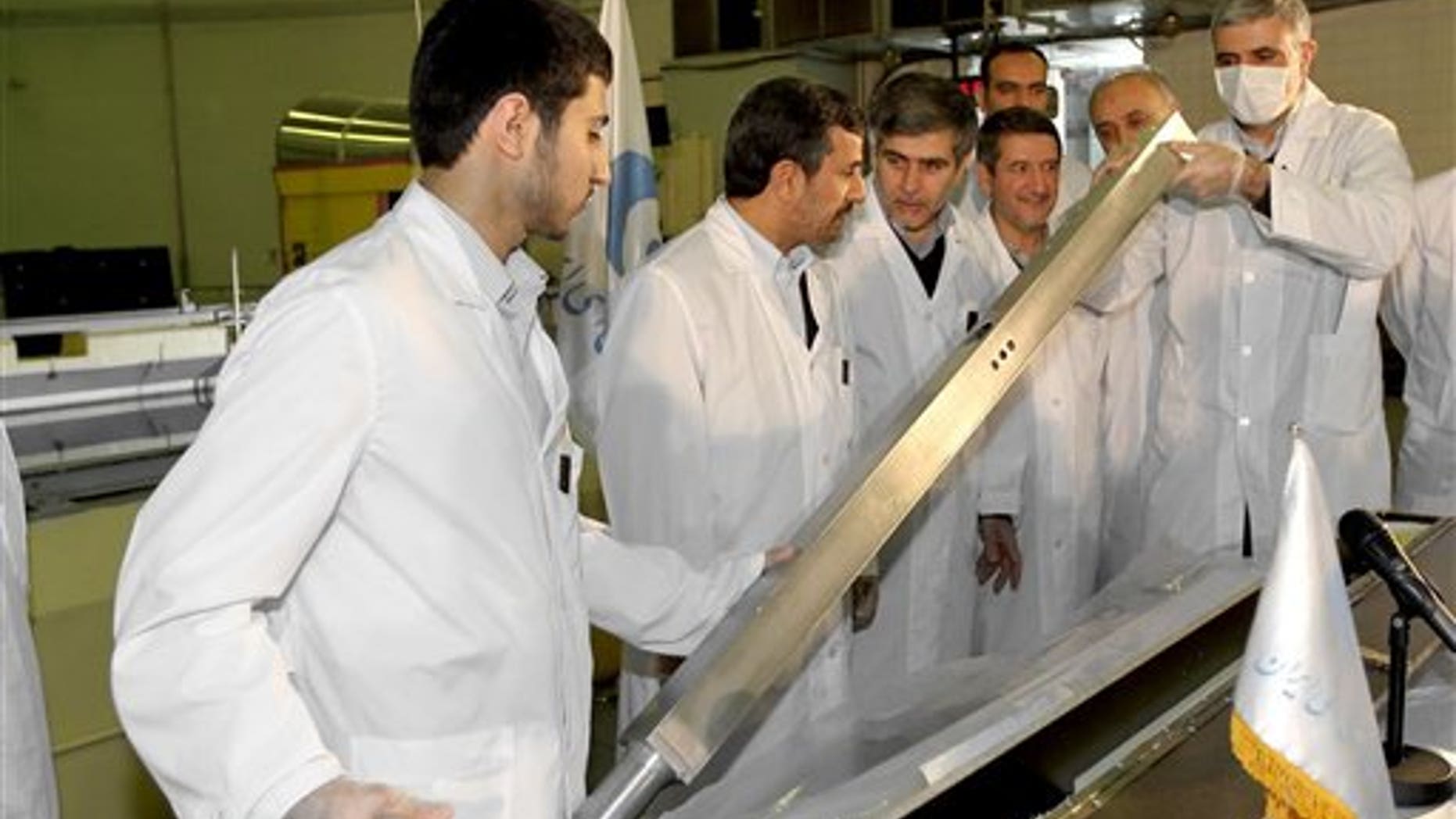 Feb. 15: This photo released by the Iranian President's Office, claims to show Iranian President Mahmoud Ahmadinejad, second left being escorted by technicians during a tour of Tehran's research reactor center in northern Tehran, Iran.