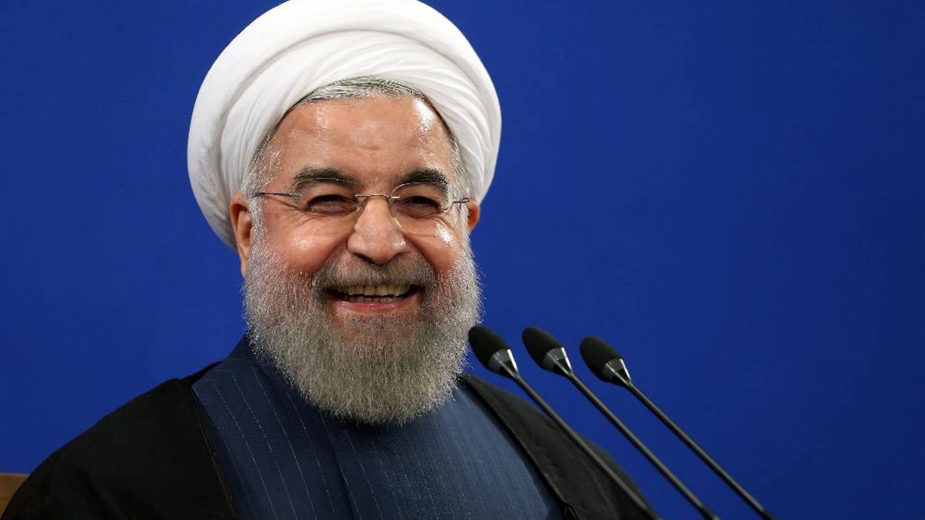 FILE - In this Aug. 29, 2015 file photo, Iran's President Hassan Rouhani smiles during his press conference in Tehran, Iran. Rouhani said Tuesday, Sept. 8, 2015 that his country is ready to hold talks with the United States and Saudi Arabia on ways to resolve the Syrian civil war, providing such negotiations can secure peace and democracy in conflict-torn Syria. Rouhani's remarks came during a press conference on Tuesday with visiting Austrian counterpart Heinz Fischer. (AP Photo/Ebrahim Noroozi, File)