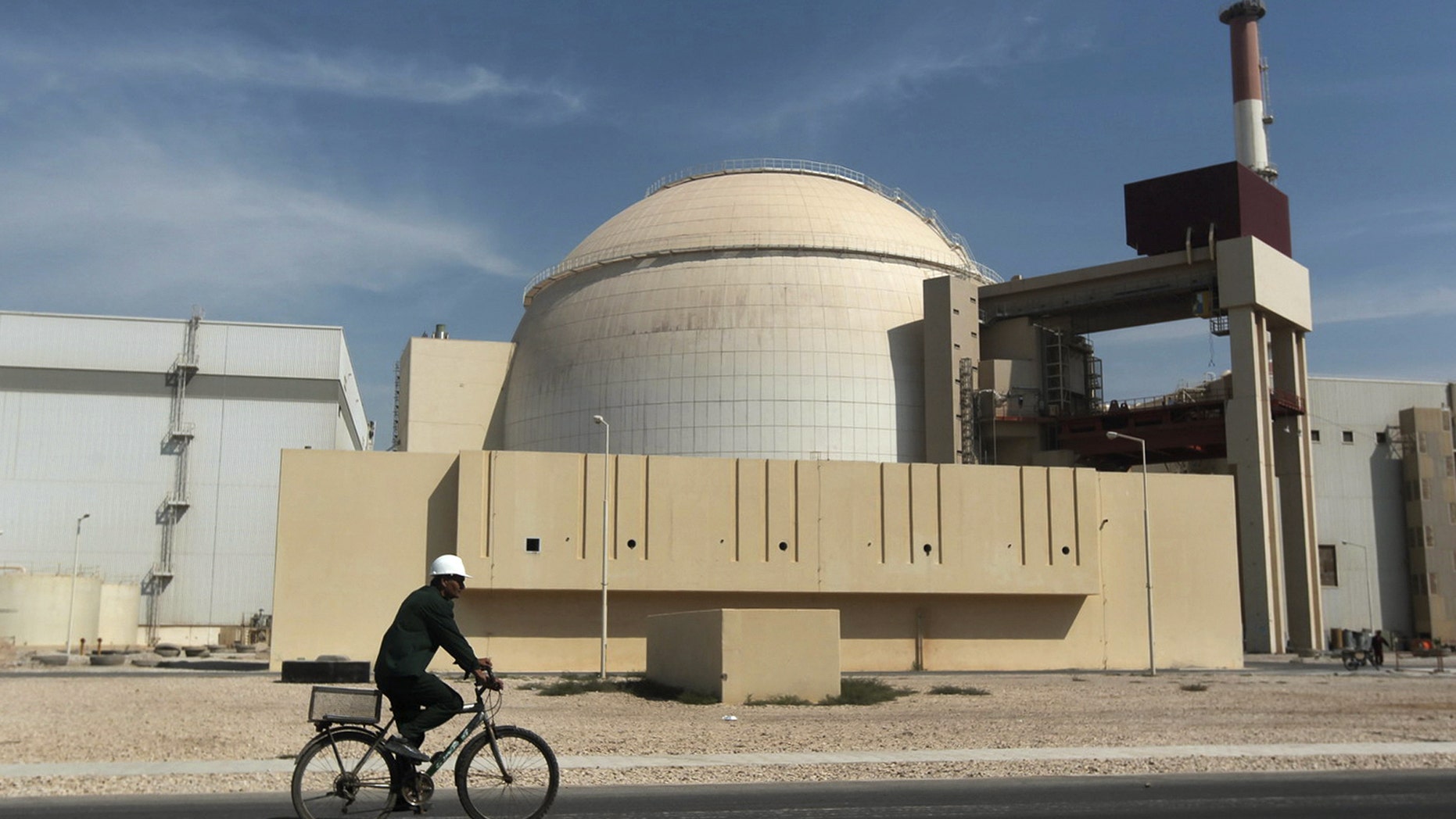 Oct. 26, 2010 - FILE photo of worker riding a bicycle in front of the reactor building of the Bushehr nuclear power plant, just outside the southern city of Bushehr, Iran. The top foreign adviser to Iran's supreme leader on Friday called for separate talks directly with the US amid the multilateral negotiations over Iran's nuclear program.