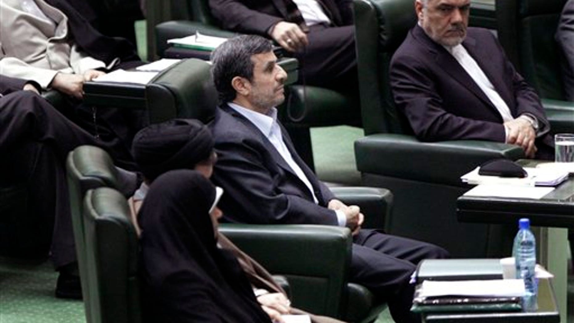 March 14: Iranian President Mahmoud Ahmadinejad, center, listens to conservative lawmaker Ali Motahari, unseen, a prominent opponent of the president, as he reads out a series of questions to Ahmadinejad in an open session in parliament in Tehran, Iran.