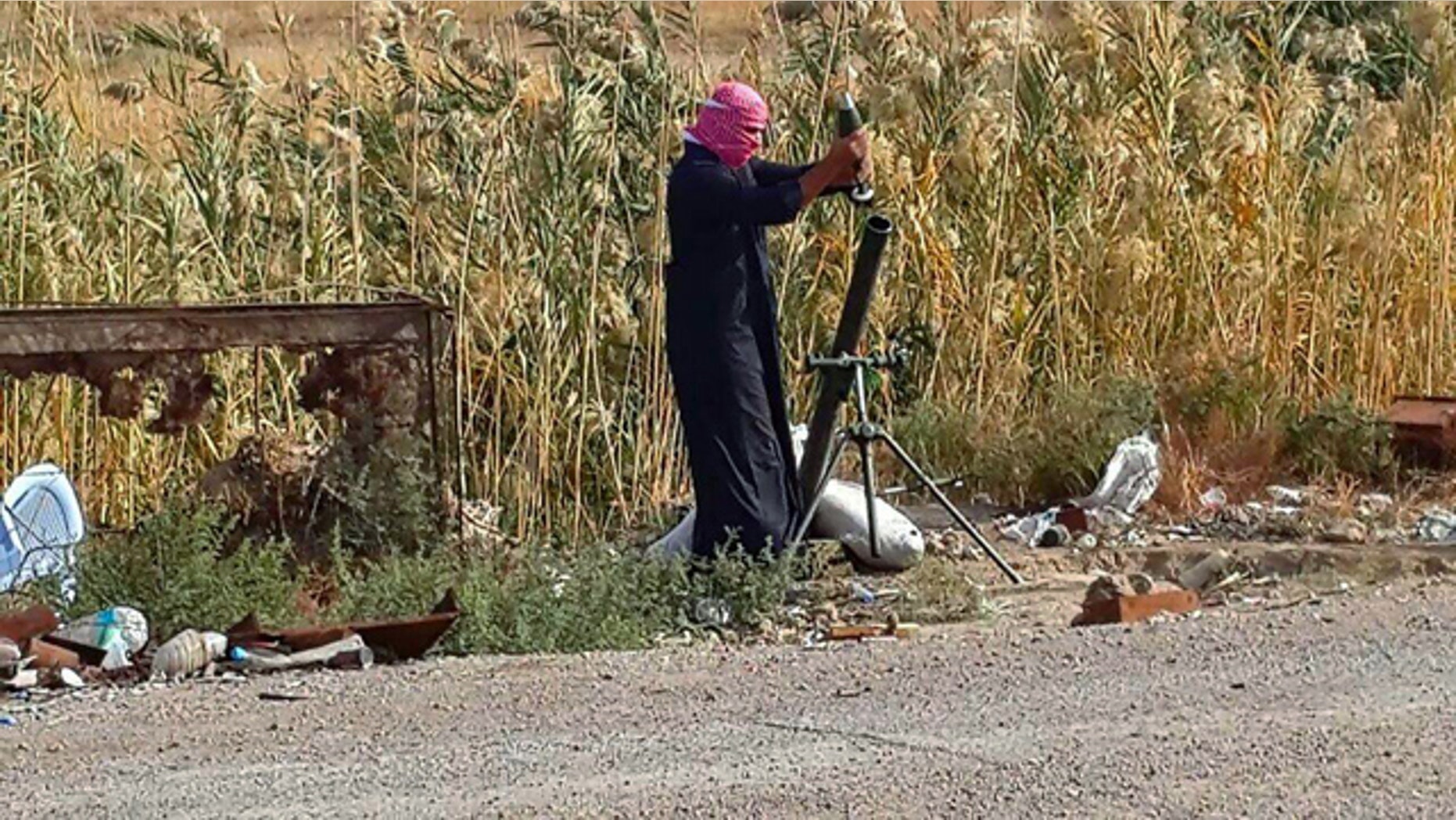 November 22, 2014: An Islamic State group fighter loads a mortar shell during clashes with Iraqi security forces in Ramadi, 70 miles west of Baghdad. (AP)