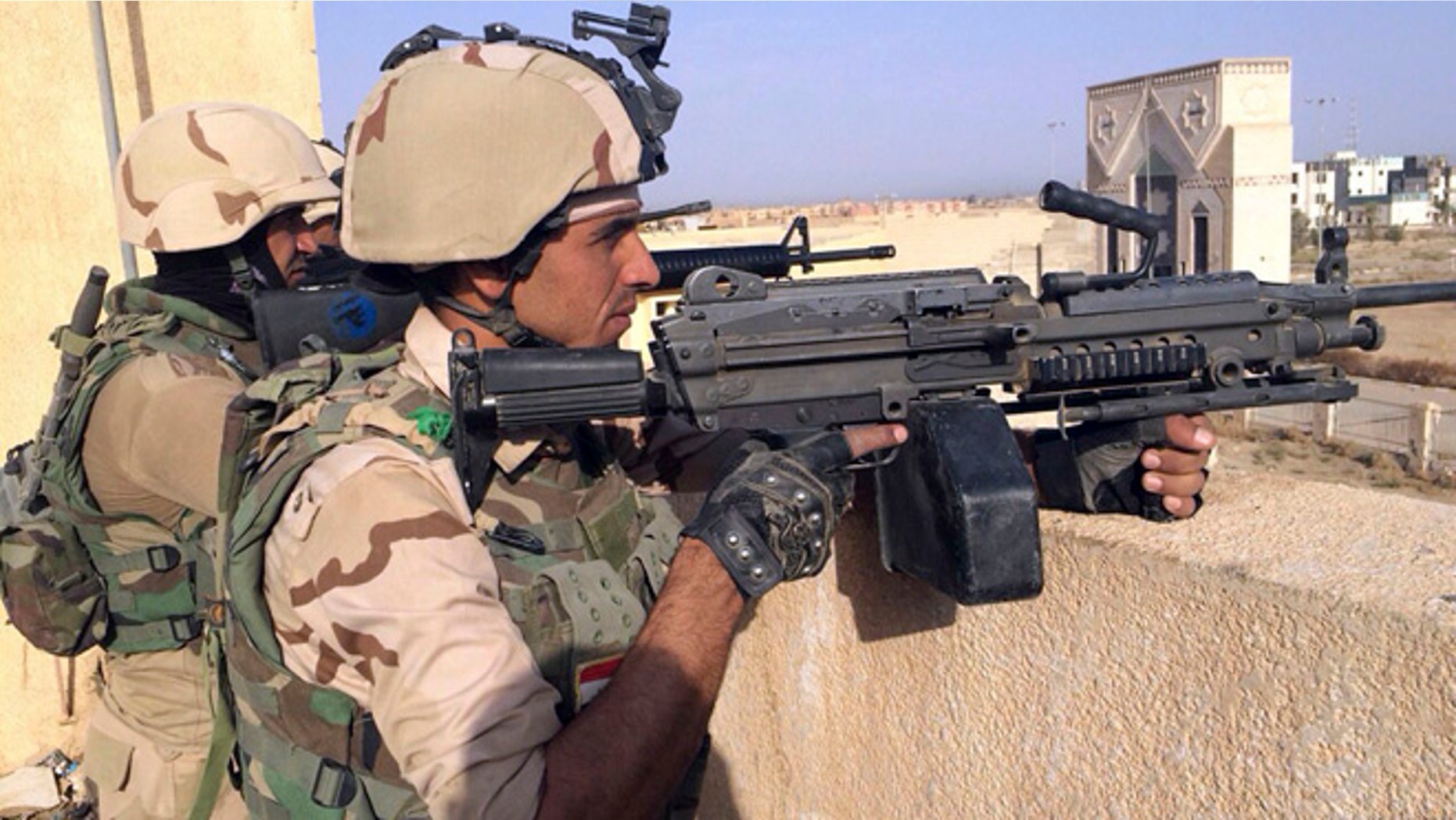 Oct. 16, 2015: Iraqi security forces stand guard after regaining control of Tamim district in southern Ramadi, Iraq.