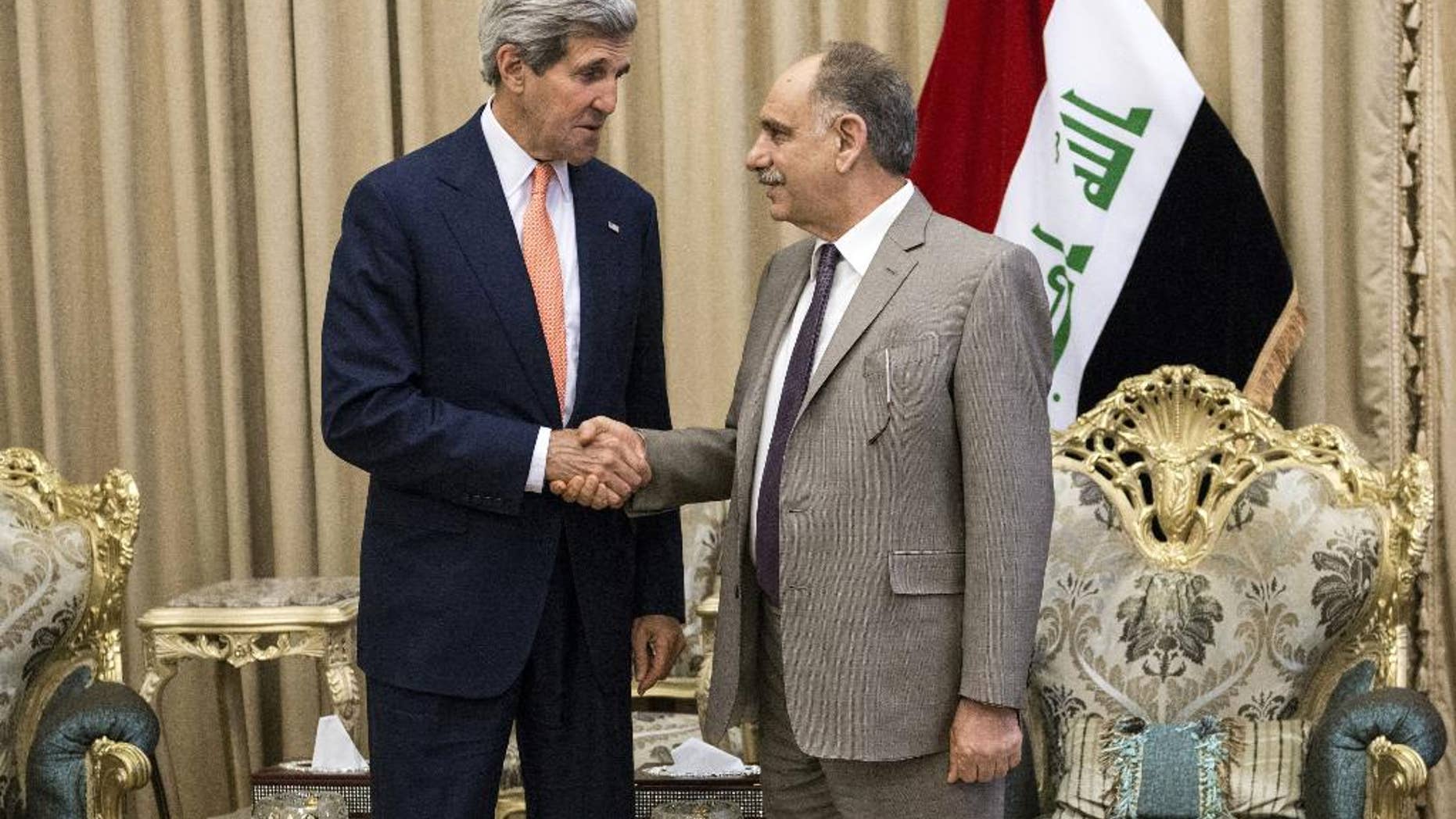 Iraqi Deputy Prime Minister Saleh al-Mutlaq, right, greets U.S. Secretary of State John Kerry before a meeting in the capital Baghdad, Iraq, Monday, June 23, 2014. Kerry said the fate of Iraq may be decided over the next week and is largely dependent on whether its leaders meet a deadline for starting to build a new government. (AP Photo/Brendan Smialowski, Pool)