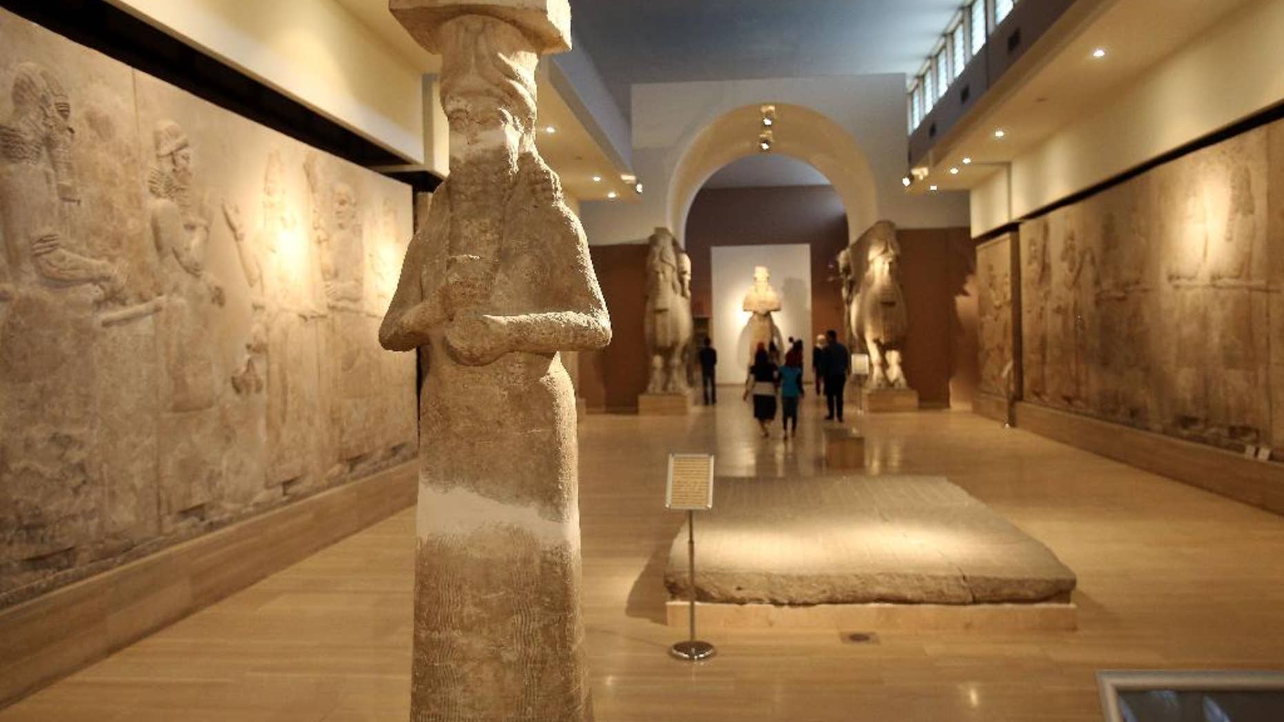 March 15, 2015: People observe ancient artifacts at the Iraqi National Museum after its reopening in the wake of the recent destruction of Assyrian archaeological sites by the Islamic State group in Mosul, as they visit the museum in Baghdad.