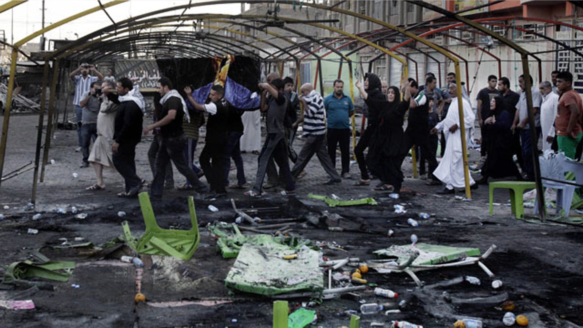 FILE - In this Sept. 22, 2013 file photo, mourners carry the coffin of a man killed on Saturday from a double suicide bomb attack in the Shiite neighborhood of Sadr city in Baghdad, Iraq. (AP Photo)