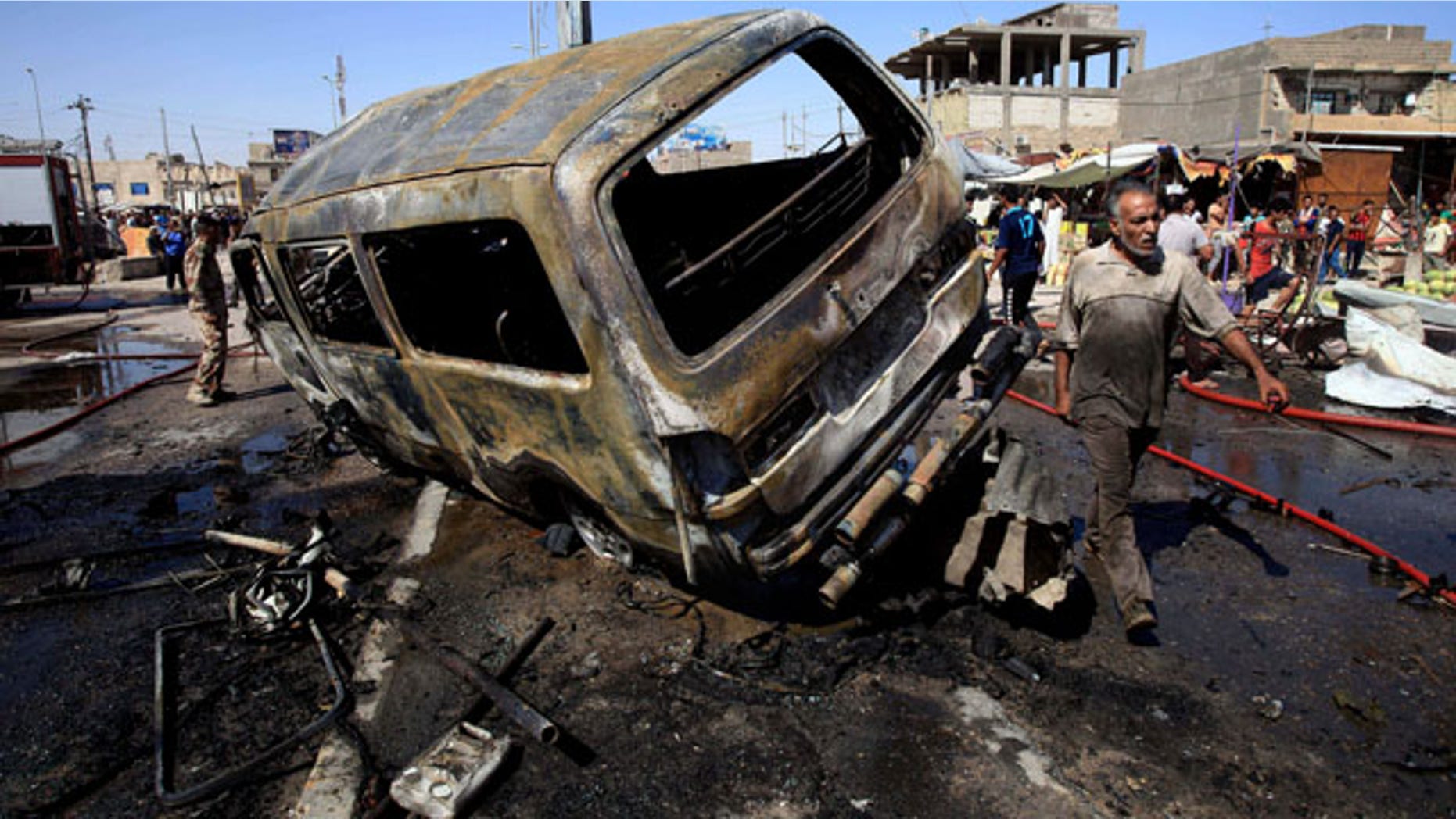 July 29, 2013: People and security forces inspect the site of a car bomb explosion in Basra, 340 miles southeast of Baghdad, Iraq.