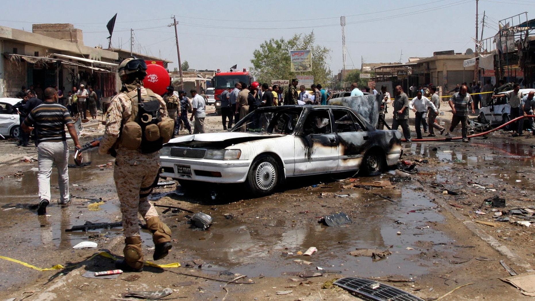 April. 29, 2013 - Civilians and security forces gather at the scene of a car bomb attack in the southern Shiite city of Karbala, south of Baghdad, Iraq.