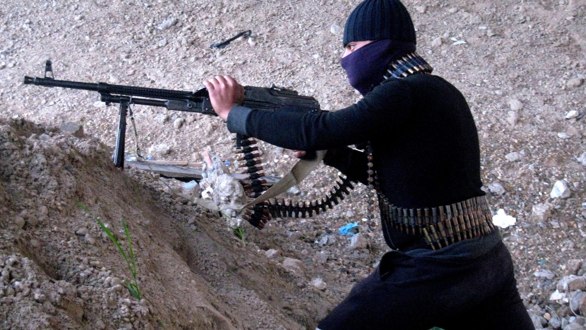 Jan. 19, 2014 - A gunmen takes cover during clashes with Iraqi security forces outside Fallujah, 40 miles west of Baghdad, Iraq.