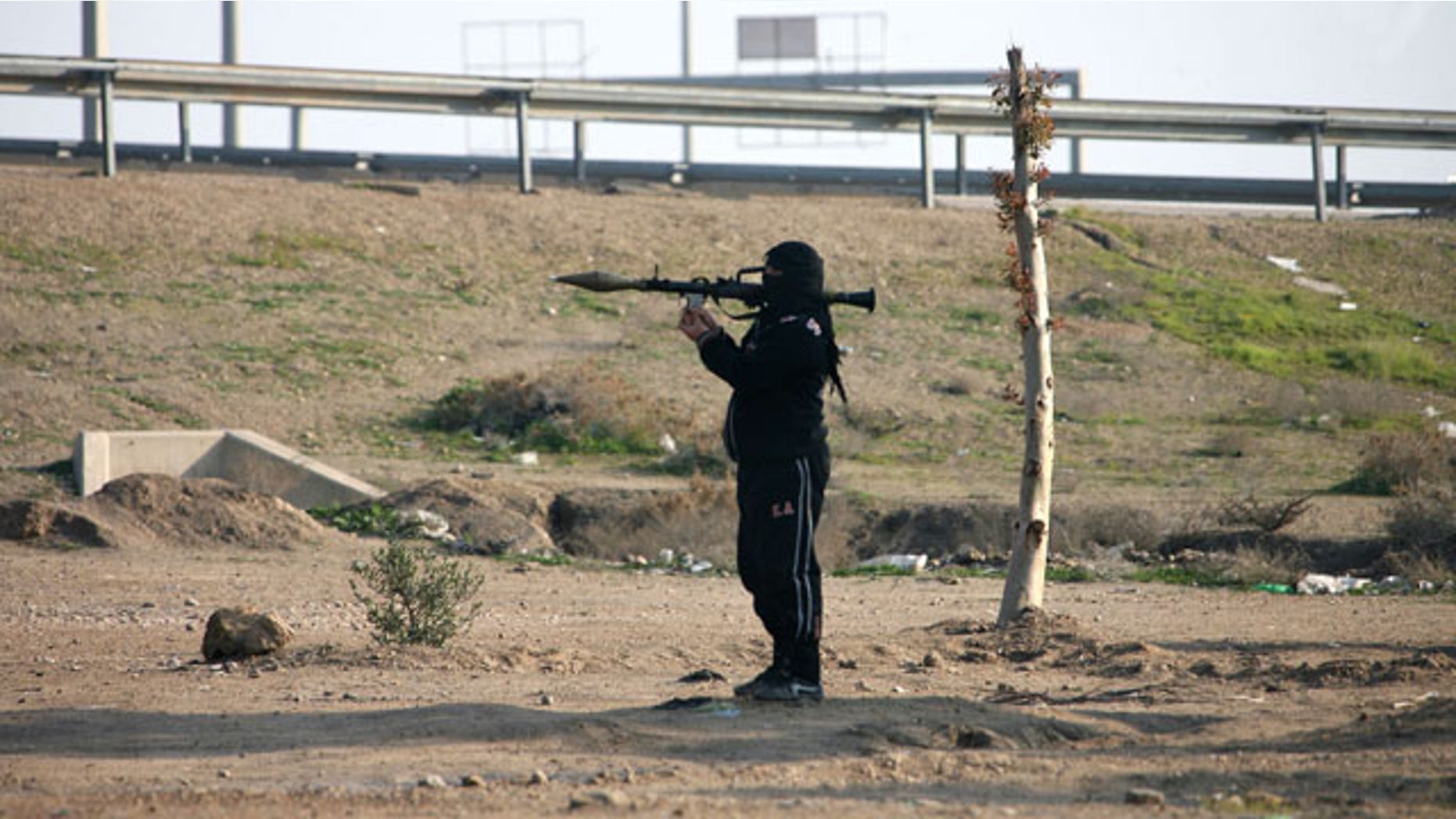 January 12, 2014: A gunman holds his weapon as he stands guard in Fallujah, 40 miles west of Baghdad, Iraq. Iraqi forces have yet to militarily try to reassert control over Fallujah, which remains in the hands of the militants and tribal gunmen opposed to the central government. (AP Photo)