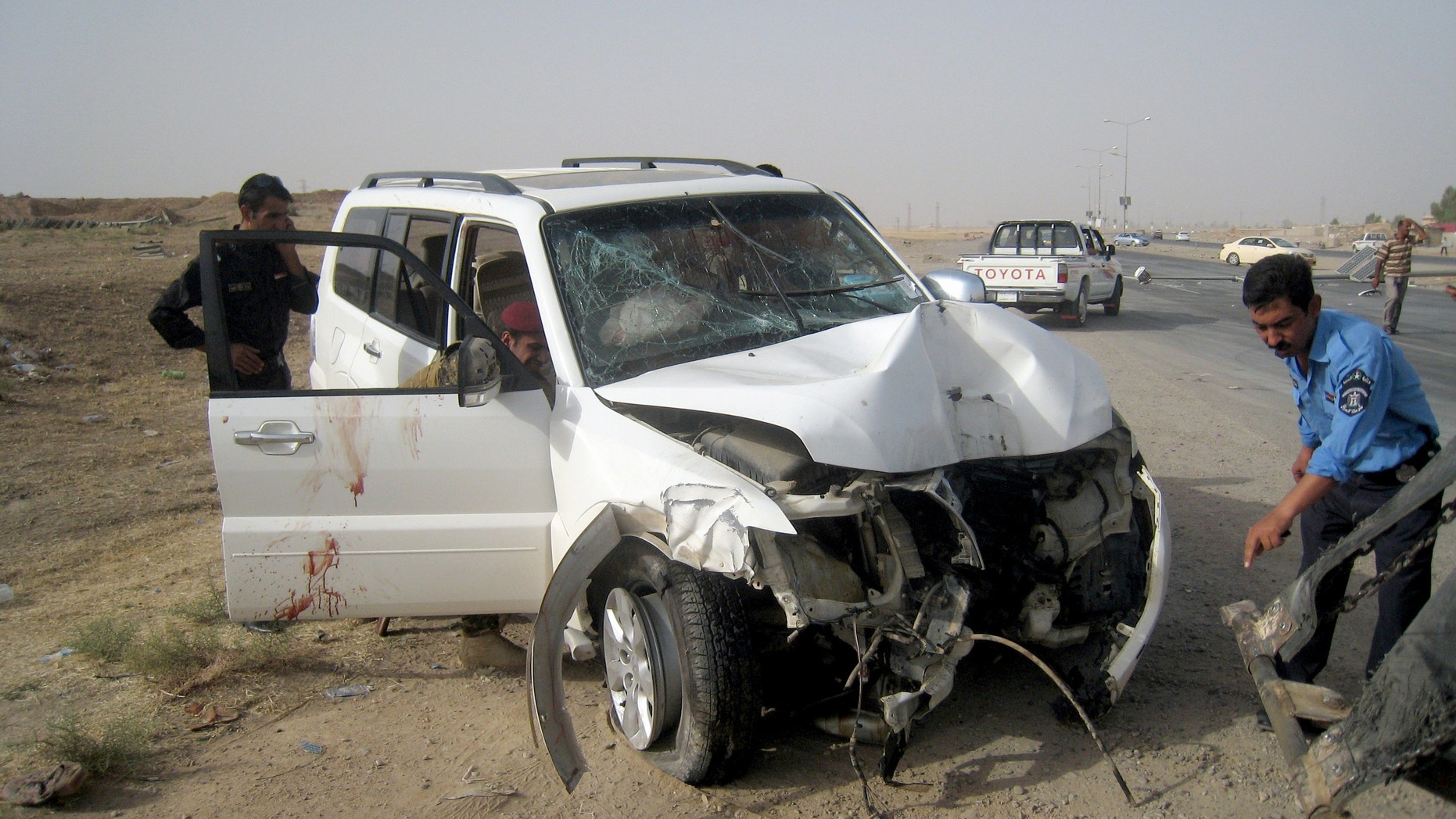 July 22, 2013 - Iraqi policemen prepare to tow away a damaged sport utility vehicle following a drive-by shooting in Kirkuk, north of Baghdad, Iraq.
