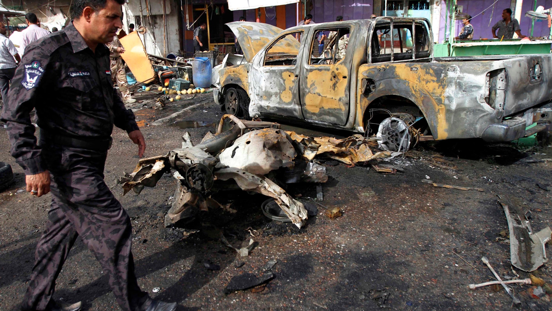 May 20, 2013 - An Iraqi police officer inspects the site of a car bomb attack in Basra, 340 miles southeast of Baghdad, Iraq.