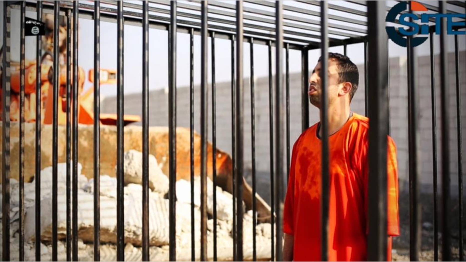 FILE - This still image made from video released by Islamic State group militants and posted on the website of the SITE Intelligence Group in this Tuesday, Feb. 3, 2015 file photo, purportedly shows Jordanian pilot Lt. Muath al-Kaseasbeh standing in a cage just before being burned to death by his captors. The video featured production techniques used in other clips from the militants. But unlike those that showed beheadings in which the hostages or their killer delivered a message before being killed, the pilot video is longer and involves a story-telling narrative and at least four cameras, along with advanced editing techniques. The death of the 26-year-old pilot, who fell into the hands of the militants in December when his Jordanian F-16 crashed near Raqqa, Syria, followed a weeklong drama over a possible prisoner exchange. (AP Photo/SITE Intelligence Group, File)