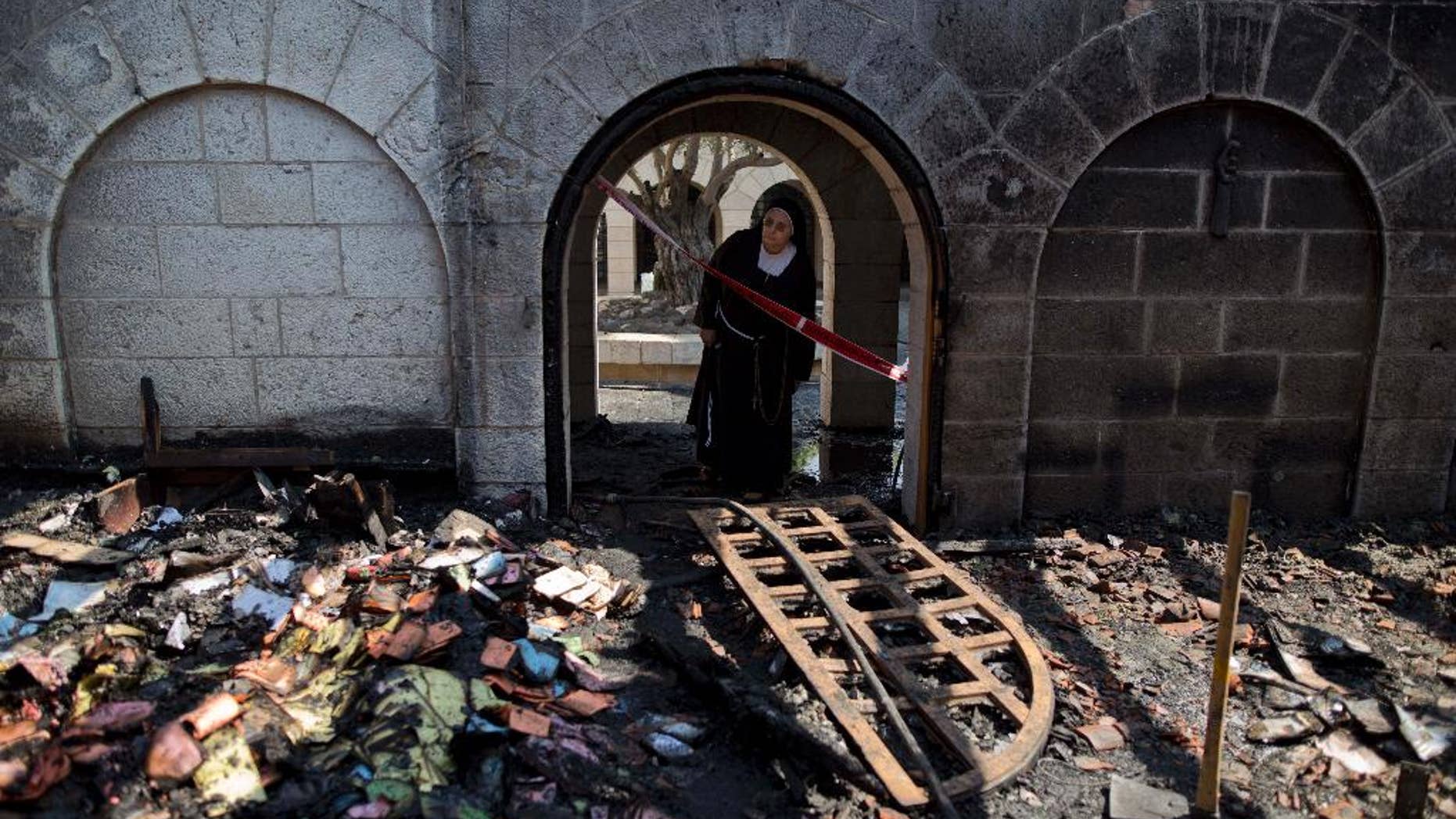 A nun looks at damage to the Church of the Multiplication of the Loaves and Fish in June 2015.