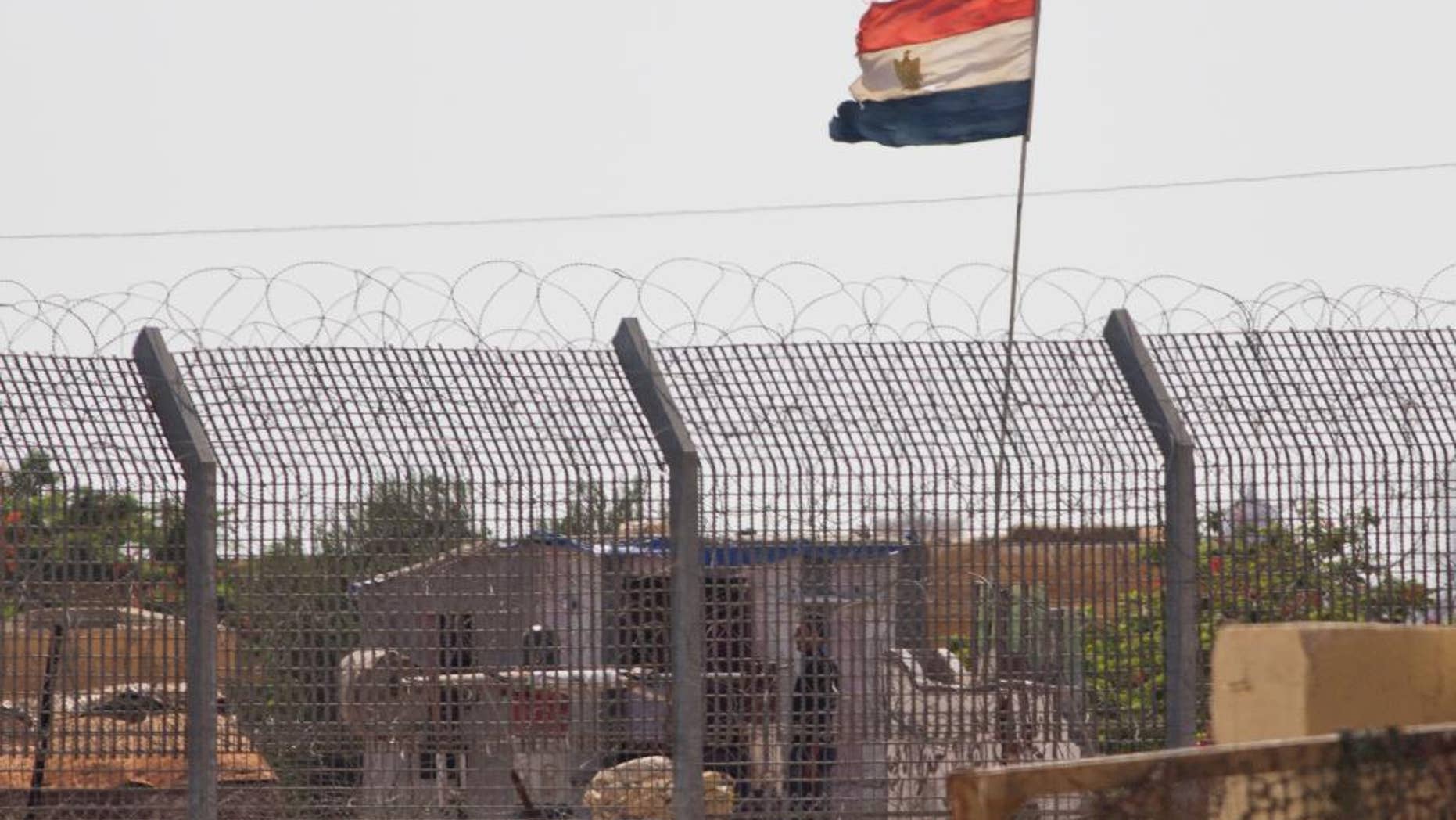 An Egyptian military officer watches at a post in Egypt's northern Sinai Peninsula, as seen from the Israel-Egypt border, in Kerem Shalom village, southern Israel, Wednesday, July 1, 2015. Islamic militants on Wednesday unleashed a wave of simultaneous attacks, including suicide car bombings, on Egyptian army checkpoints in the restive northern Sinai Peninsula, killing tens of soldiers, security and military officials said. (AP Photo/Ariel Schalit)