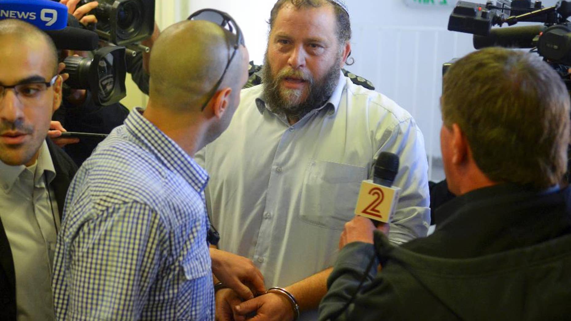 Bentzi Gopstein, leader of the extreme right-wing movement Lehava, is handcuffed as he arrives for his hearing at a Jerusalem Court, Tuesday, Dec. 16, 2014. Israeli police on Tuesday arrested 10 Jewish activists from an extremist group opposed to Arab-Jewish coexistence, including its leader, in the first major clampdown against a fringe organization that has become a symbol of rising anti-Arab sentiment. (AP Photo/Mahmoud Illean)