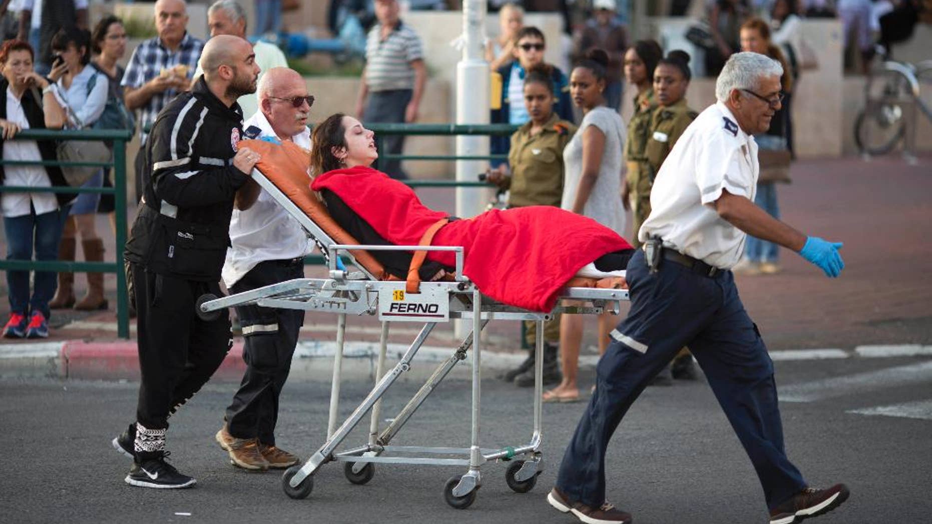 FILE - In this Monday, Nov. 2, 2015 file photo, Israeli rescue personal evacuate a woman after a stabbing attack in Rishon Lezion, Israel. After years of relative quiet in major Israeli cities, a seven-week burst of violence has brought the Palestinian issue back to the country’s heartland and pushed the long-festering issue onto the national agenda. (AP Photo/Ariel Schalit, File)
