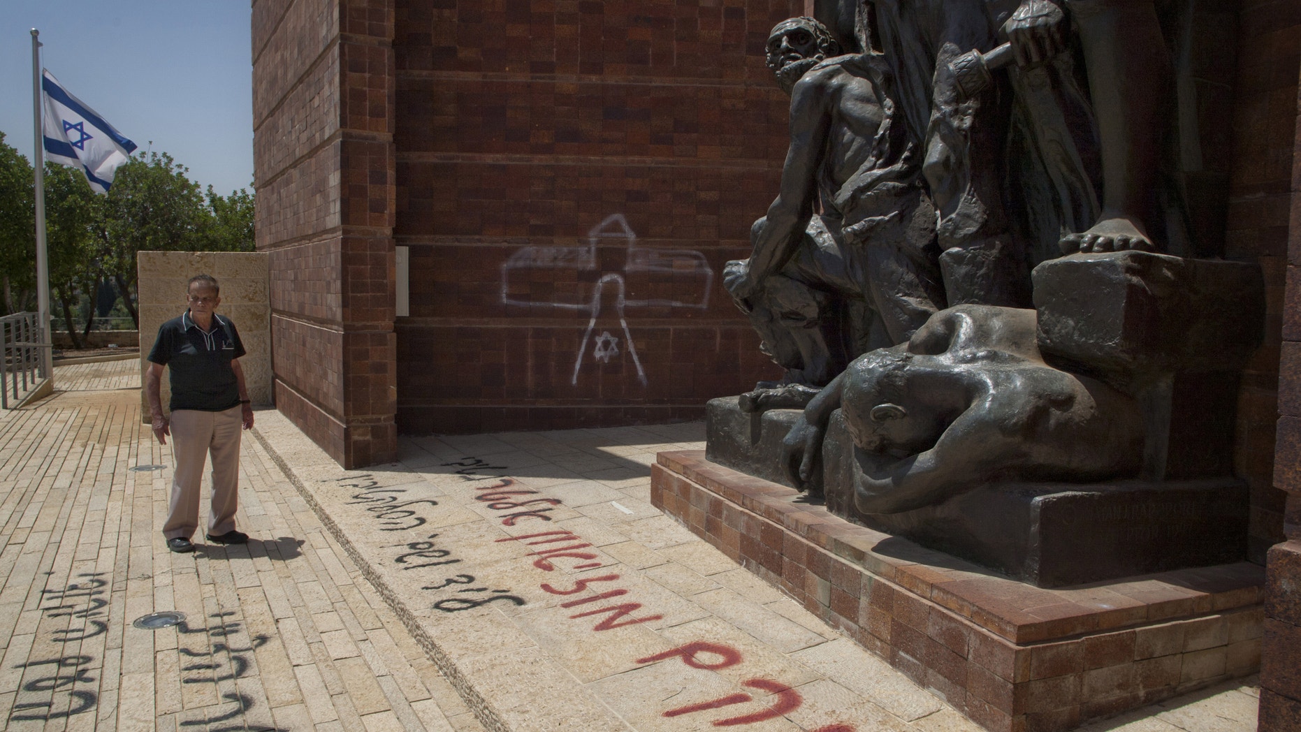 June 11, 2012: Matityahu Drobles, a Holocaust survivor and former member of Israel's parliament, looks at anti-Zionist graffiti sprayed on the Yad Vashem Holocaust memorial compound in Jerusalem.