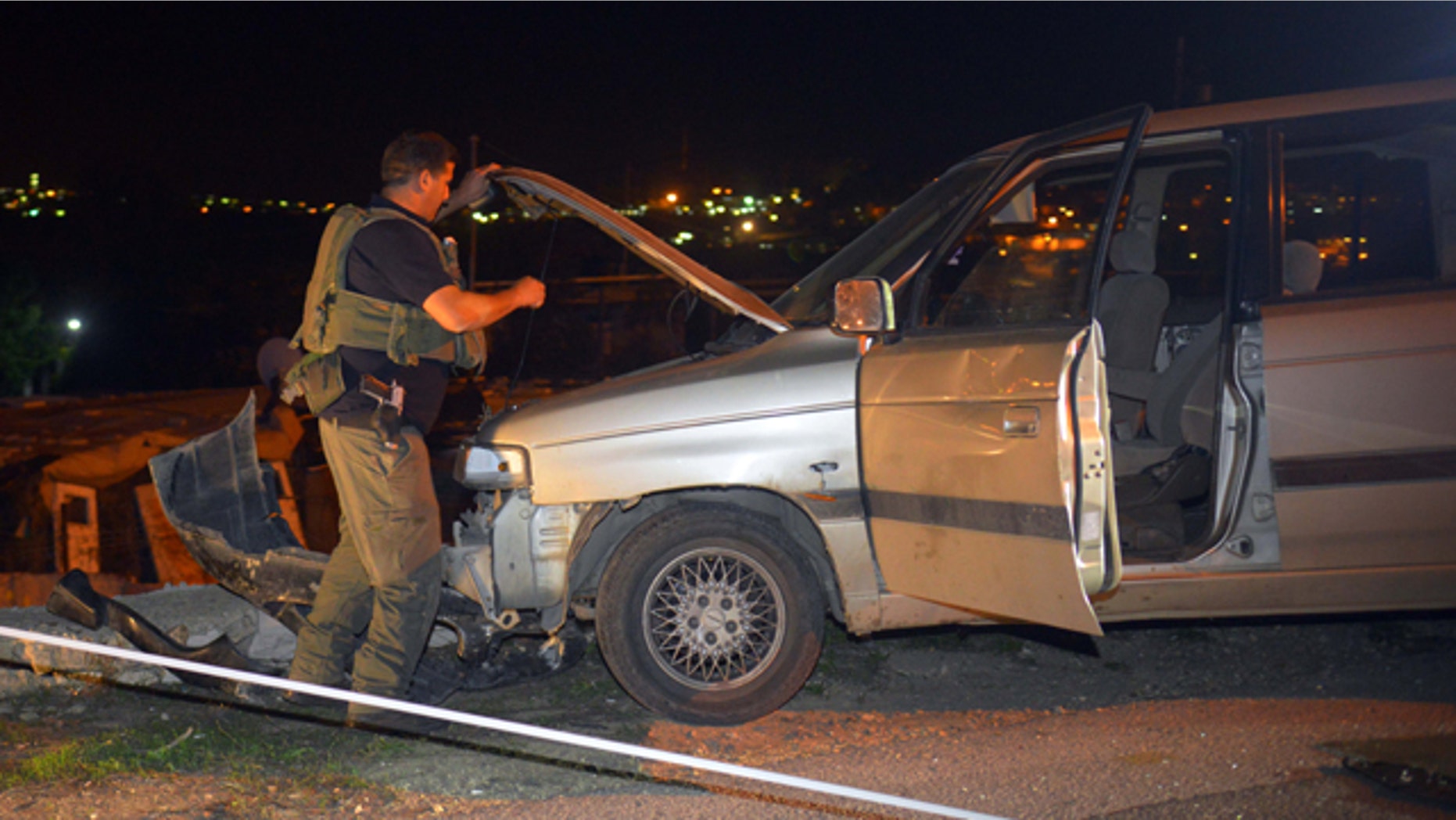 November 10, 2014: An Israeli soldier inspects a vehicle at the scene of an attack near the West Bank Jewish settlement of Alon Shvut. (AP Photo/Mahmoud Illean)