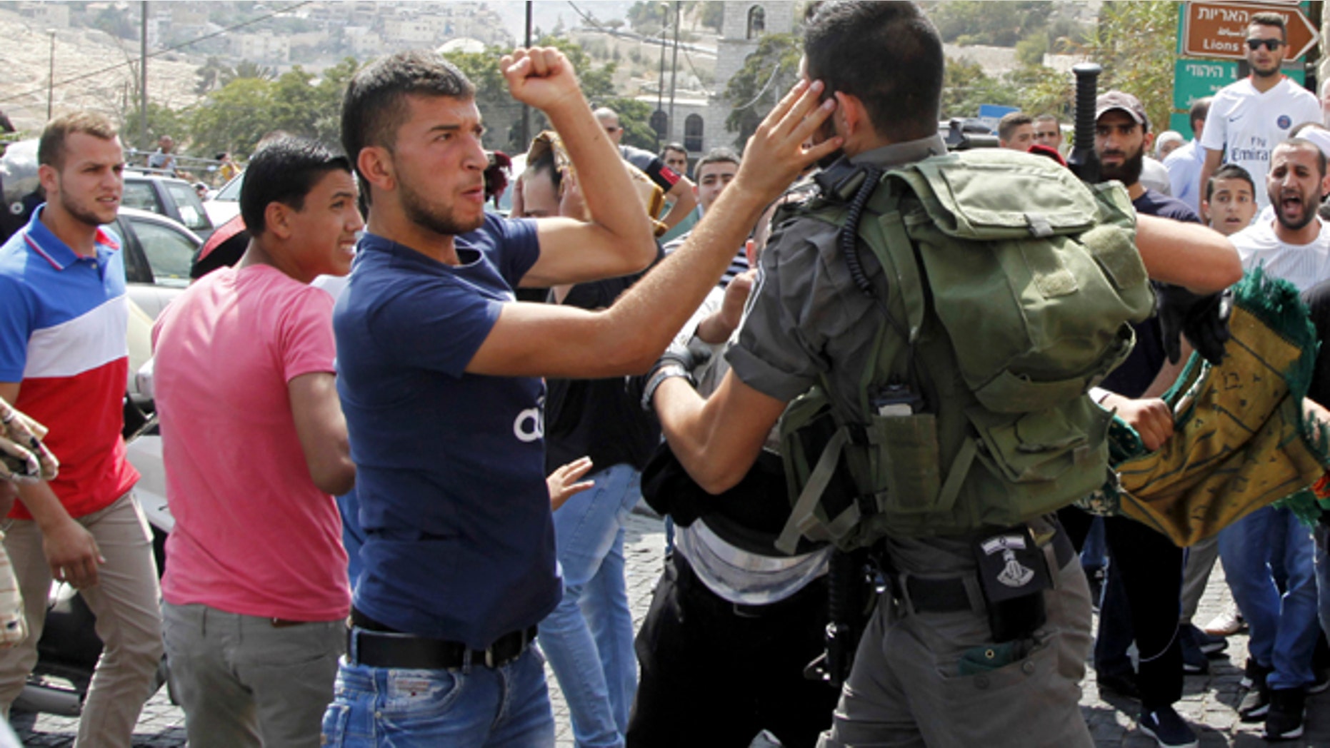 Oct. 2, 2015: An Israeli border policeman exchanges blows with a Palestinian man during a confrontation after Friday prayers outside the Old City in Jerusalem.