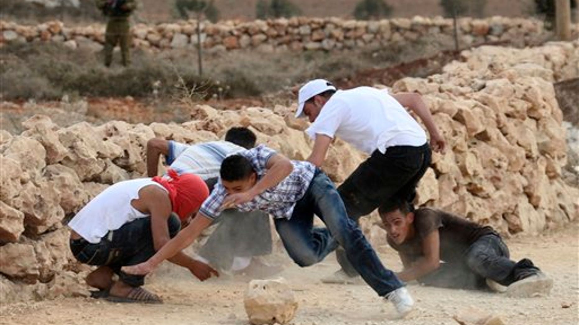 September 23: Palestinians scramble for cover during a clash with Israeli forces in the village of Qusra, south of Nablus, in the West Bank.