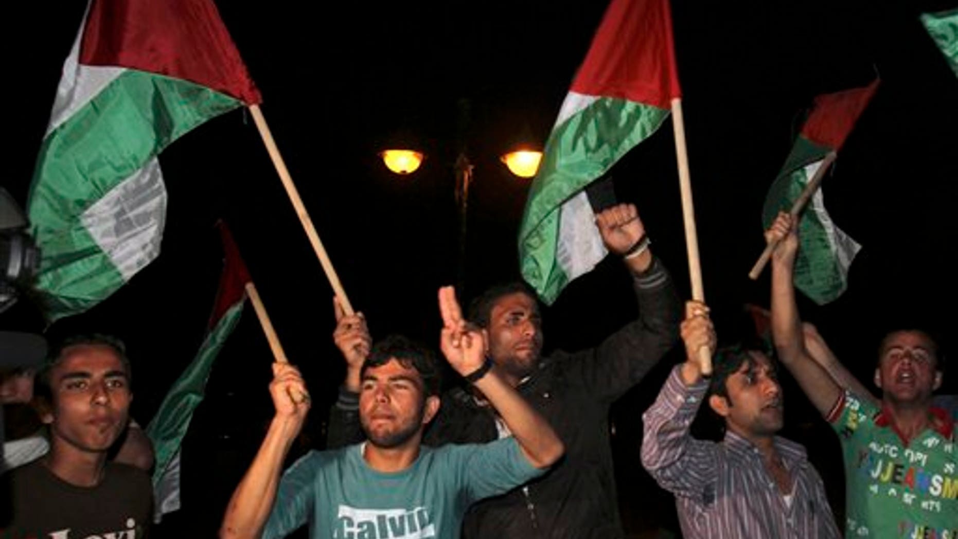 April 27: Palestinians wave flags and chant slogans in support of a reconciliation between the rival Fatah and Hamas movements, in Gaza City. Palestinians have reached initial agreement on reuniting their rival governments in the West Bank and Gaza, officials from both sides said Wednesday, a step that would remove a main obstacle in the way of peace efforts with Israel. (AP)