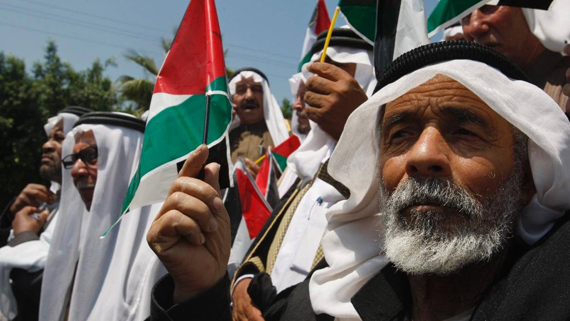 FILE - In this Wednesday, May 11, 2011 file photo, Palestinians wave flags as they celebrate the reconciliation between rival factions Fatah and Hamas, during a rally in Gaza City. President Mahmoud Abbas said a dark period in Palestinian history has ended with the formation of a unity government that formally ends his seven-year rift with the Islamic militant Hamas. But the alliance of old foes remains volatile, while Israel threatens punitive measures and Abbas doesn't know yet if he'll get continued financial aid from the U.S. and Europe to keep the unity government afloat. (AP Photo/Hatem Moussa, File)