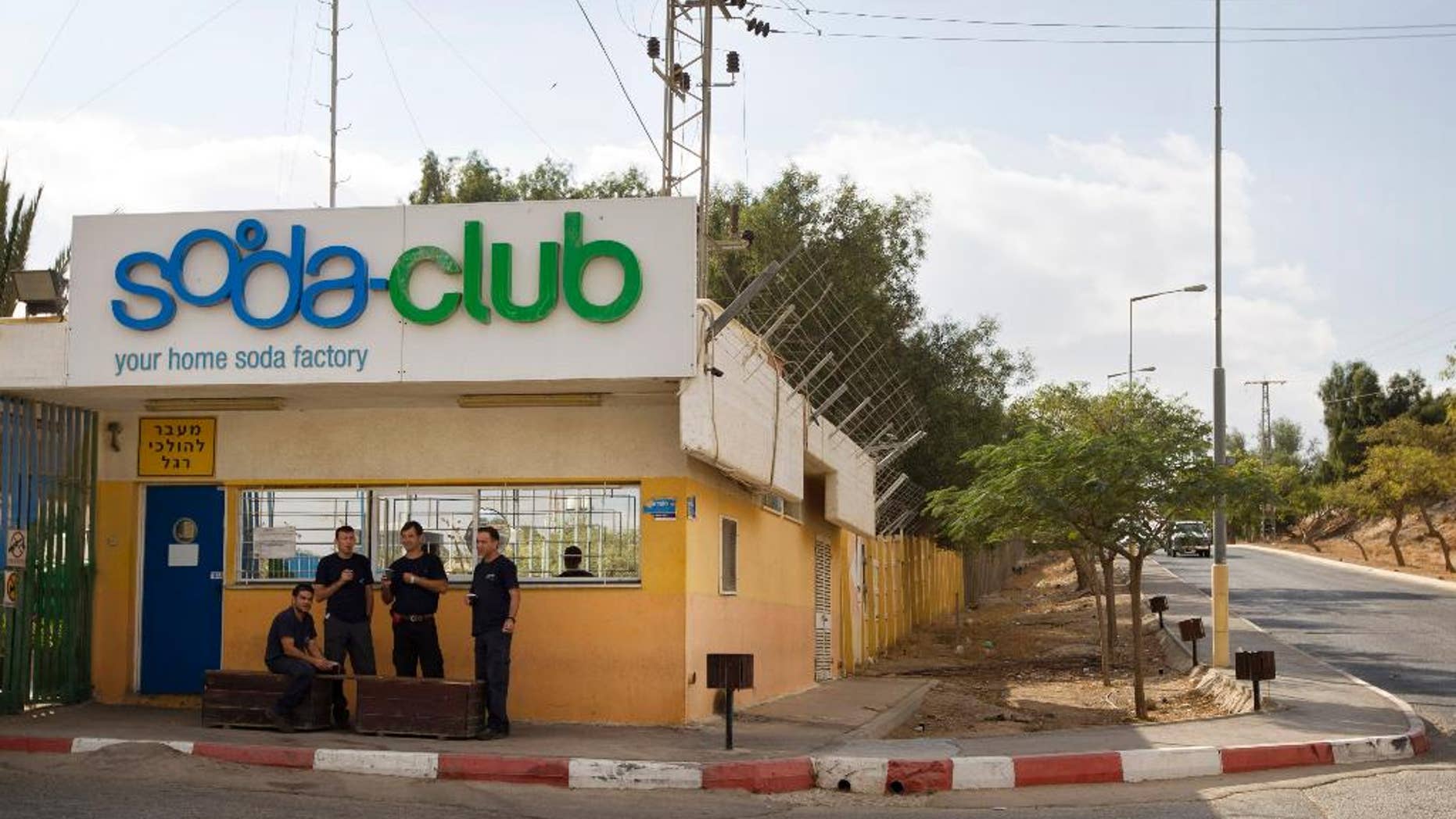 FILE - In this Nov. 22, 2010 file photo, workers stand at the entrance to the Soda Club factory in the Mishor Adumim industrial zone near the Jewish West Bank settlement of Maaleh Adumim. Israeli drink maker SodaStream International Ltd. is to relocate its factory in an Israeli Maaleh Adumim settlement in the West Bank next year to southern Israel, a representative said Wednesday saying the move is strictly for commercial reasons and not due to pressure by pro-Palestinian activists. (AP Photo/Sebastian Scheiner, File)