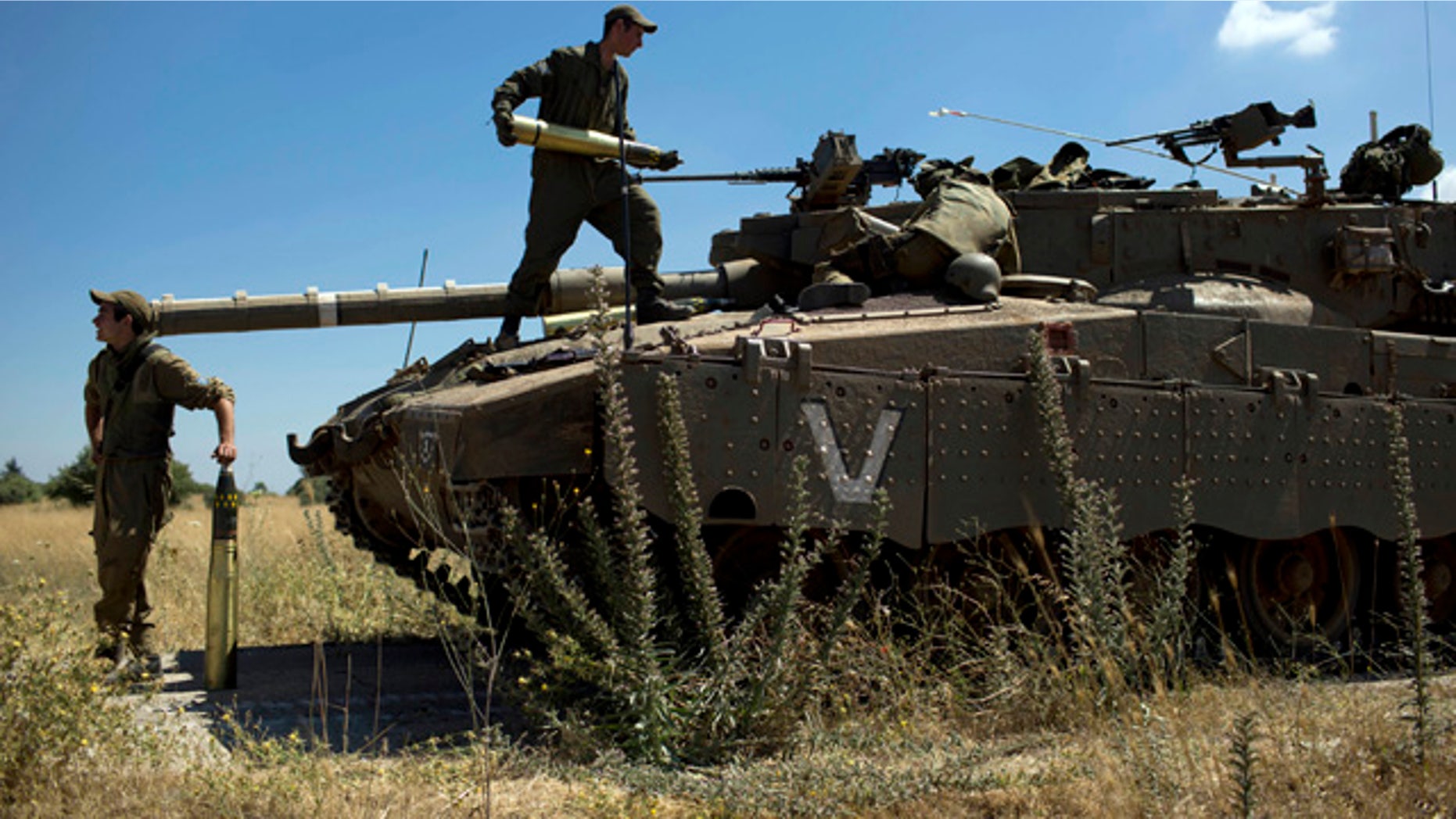 June 22, 2014: Israeli soldiers load shells in their tank following the first death on the Israeli side of the Golan since the Syrian civil war erupted more than three years ago, near the Israeli village of Alonei Habashan, in the area of Tel Hazeka, close to the Quneitra border crossing in the Israeli-controlled Golan Heights. (AP Photo/Oded Balilty)