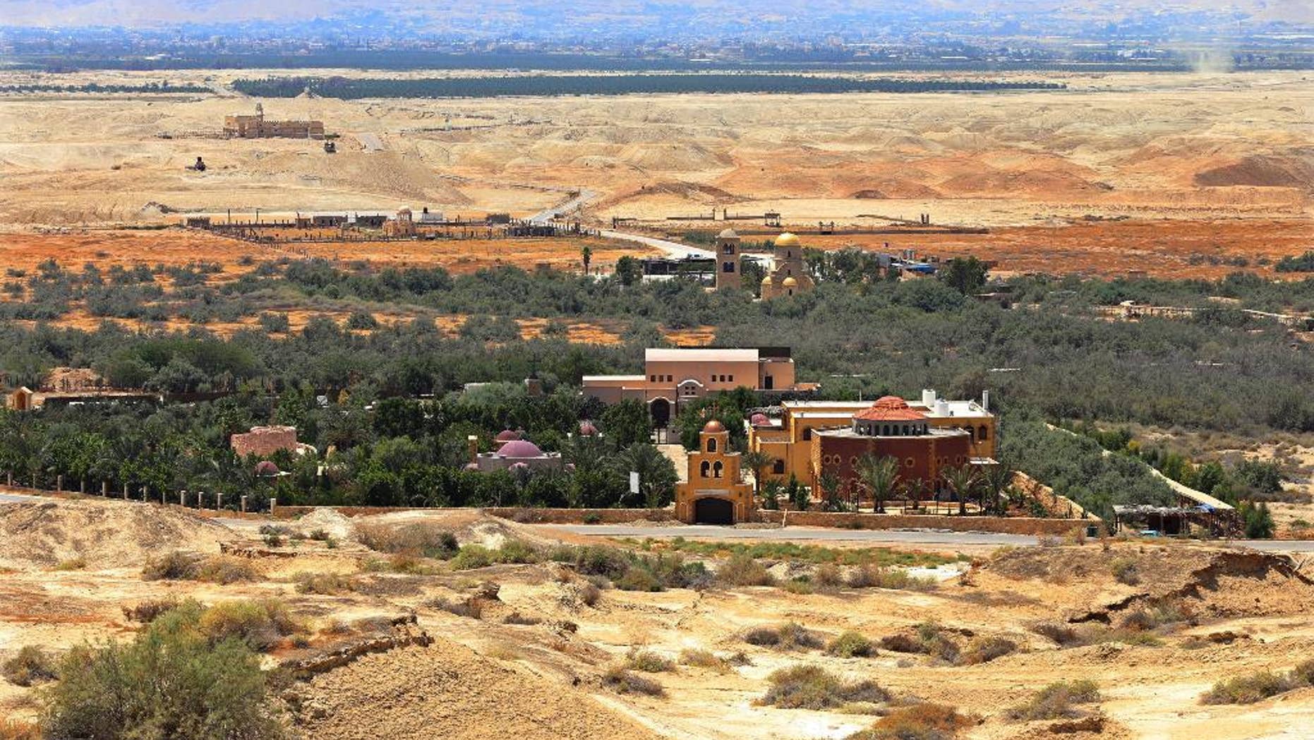 This July 6, 2015 photo shows the baptismal area on the eastern bank of the Jordan River in South Shuna, Jordan, foreground, and the baptismal area of the Israeli-run site known as Qasr al-Yahud, with the golden dome church, background, located in a part of the West Bank. UNESCO recently designated Jordan's baptismal area a World Heritage site, over the Israeli-run site of Qasr al-Yahud in the West Bank, which is one of three territories captured by Israel in the 1967 Mideast war. (AP Photo/Raad Adayleh)