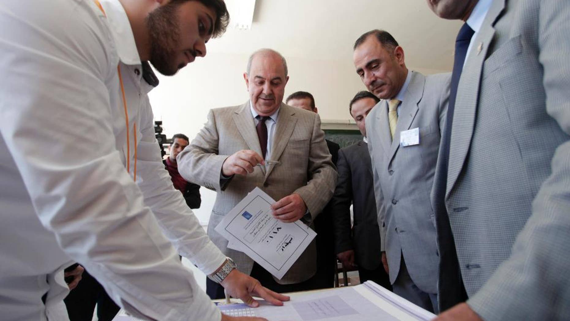 Ayad Allawi, the leader of Iraq's main Sunni-backed Iraqiya bloc and former Prime Minister, center, arrives at a polling station as his identity is checked by one of the voting watchers, for the Iraqi parliamentary election, in Amman, Jordan, Sunday, April 27, 2014. After voting Allawi expressed his views on the election, “really this is a shameful kind of elections, and I can categorize it by an election which is not worthy, not up to the standards of the Iraqi people, but this is the only way for change in Iraq, and I call upon all Iraqis to go to the ballot boxes to cast their votes to change the current situation,”Allawi said. (AP Photo/Mohammad Hannon)