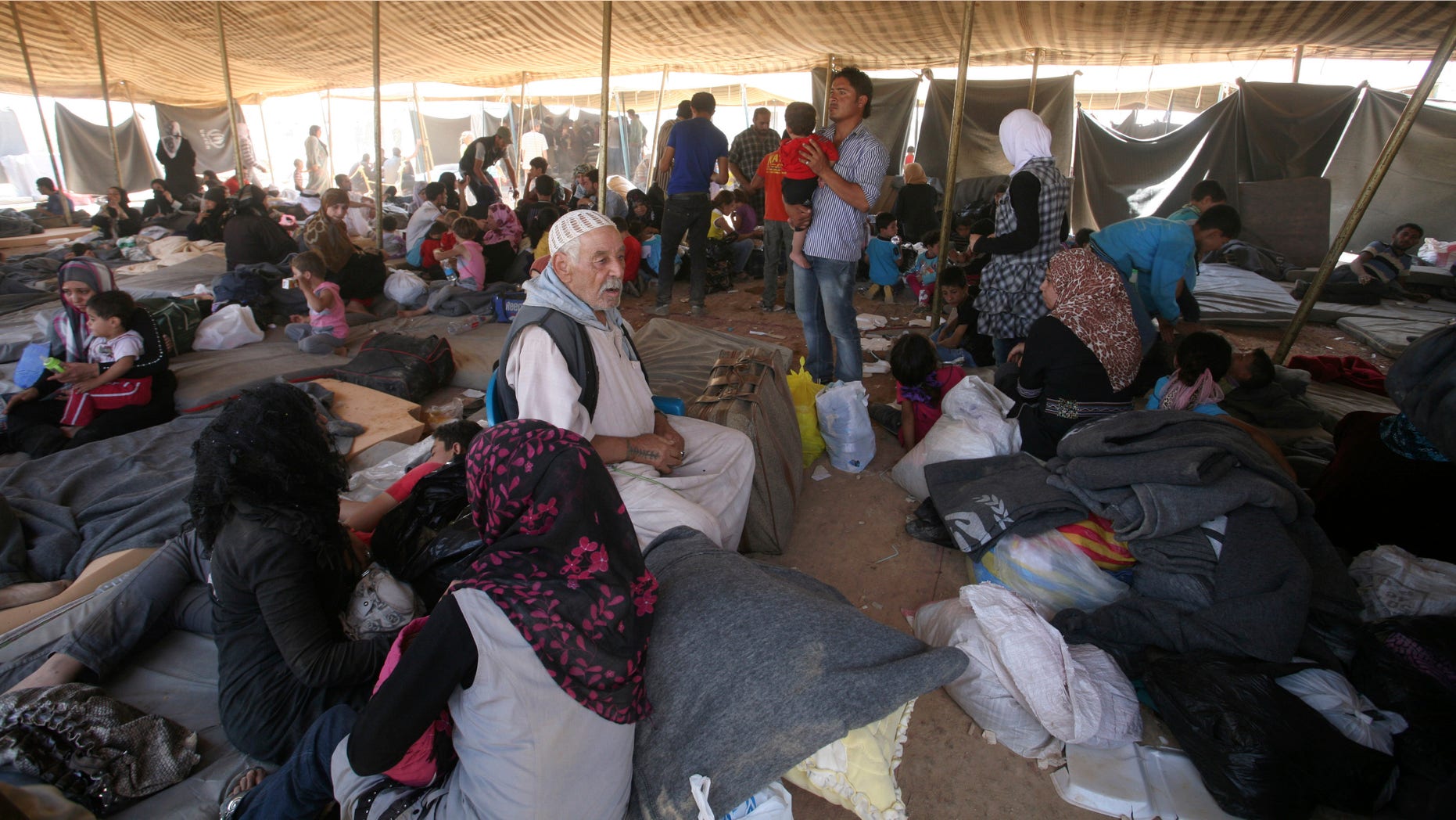 Newly-arrived Syrian refugees gather at Zaatari refugee camp, in Mafraq, Jordan, Wednesday, Aug. 29, 2012. Jordan's has warned Syrian refugees in its tent camp near the Syrian border against rioting. Public security officials say rioting by 200 refugees late Tuesday over the camp's 'poor services' injured 26 Jordanian security officers. (AP Photo/Mohammad Hannon)