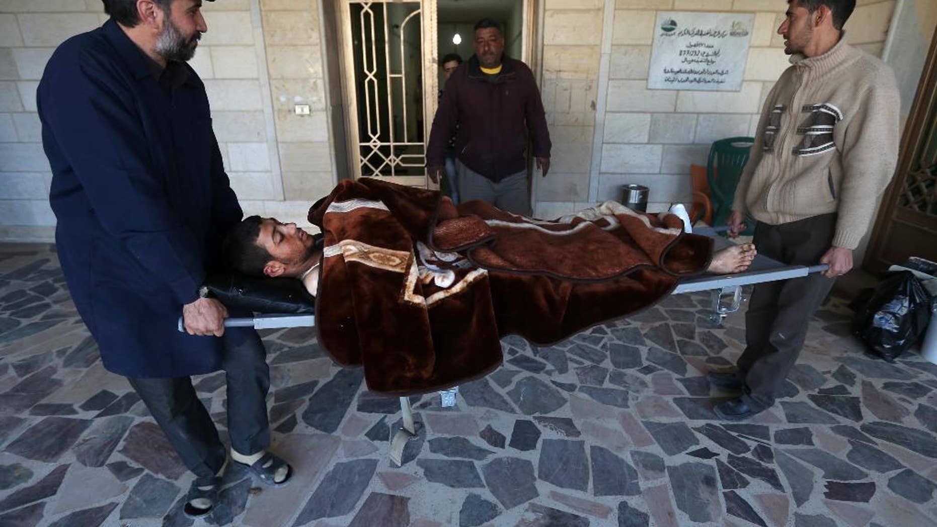In this picture taken on Wednesday, March 5, 2014, a Lebanese nurse, left, and Syrian man, right, carry Adul-Karim, 18, a Syrian rebel who was injured during a battle against the Syrian government forces and Hezbollah fighters in Rima village near Yabroud, the last rebel stronghold in Syria's mountainous Qalamoun region, as they move him from a makeshift hospital to a rest house after he received his medical treatment, in the Lebanese-Syrian border town of Arsal, eastern Lebanon. Trucks of armed fighters rumble from this Lebanese Sunni town through the mountains to the front in Syria, where rebels are in a furious fight to keep a vital stronghold. At the same time, Lebanese Shiite fighters from a town not far away are also streaming in to join the battle _ but on the opposing side, backing Syrian government forces. The battle has effectively erased the border between the two countries and underlines how dangerously Lebanon is being sucked into its neighbor’s civil war. (AP Photo/Hussein Malla)