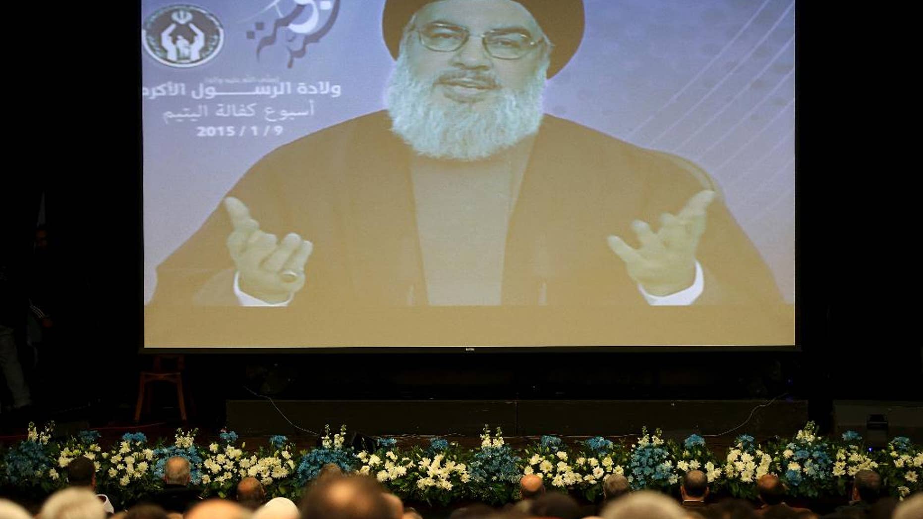 Hezbollah leader Sheikh Hassan Nasrallah speaks via video to his supporters in the southern suburb of Beirut, Lebanon, Friday Jan. 9, 2015. The leader of the Lebanese Hezbollah group said Islamic extremists have insulted the prophet of Islam with their terror more than those who published drawings mocking him. (AP Photo/Hussein Malla)