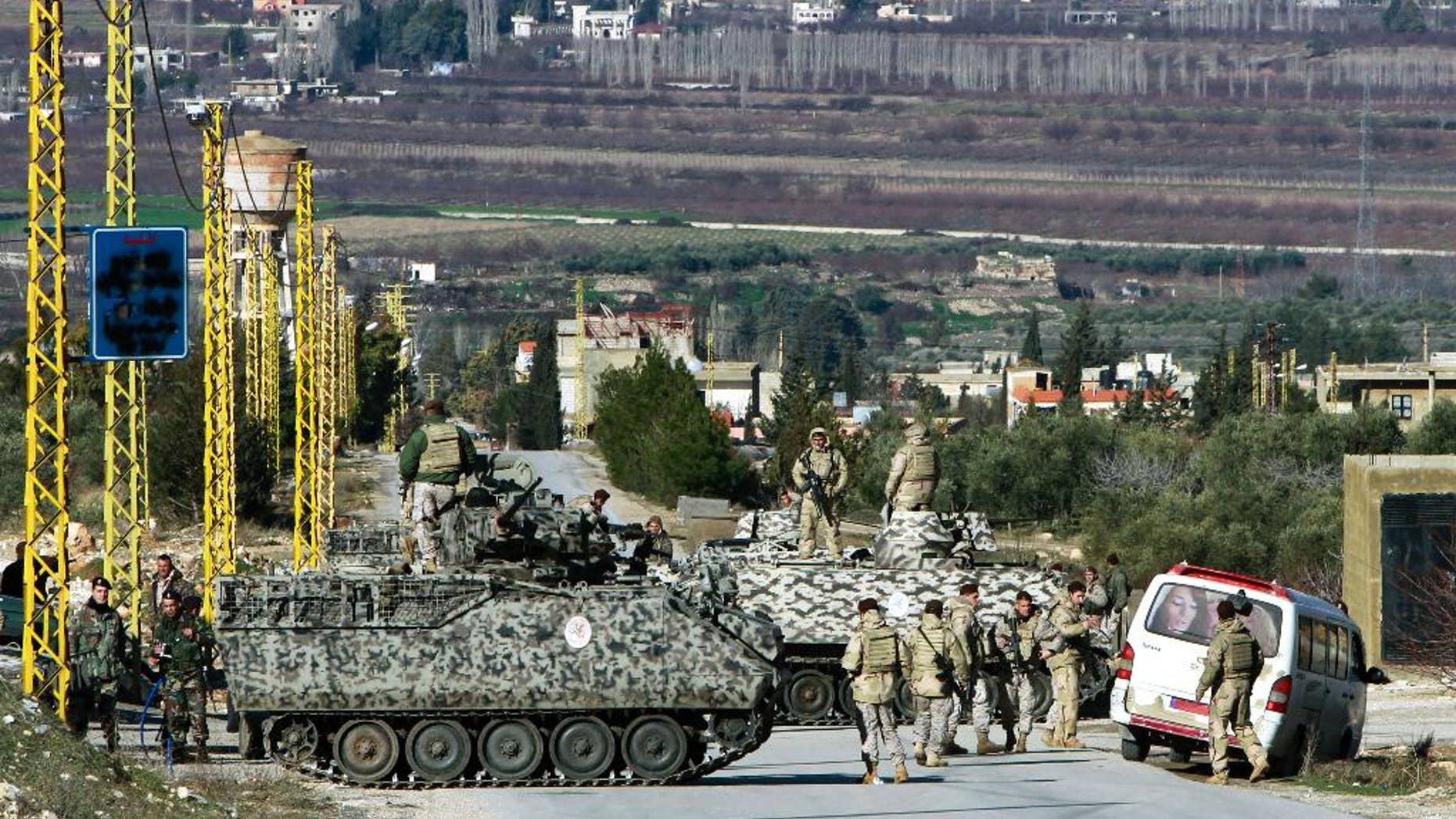 FILE - In this Saturday, Feb. 2, 2013 file photo, Lebanese army soldiers search civilians at a checkpoint for the entrance of Arsal, a Sunni Muslim town near the Syrian border in eastern Lebanon. A suicide bomber driving an explosives-laden car targeted a Lebanese army checkpoint near the Syrian border on Saturday, March 29, 2014, killing and wounding several soldiers, Lebanon's official news agency reported. (AP Photo/Bilal Hussein, File)