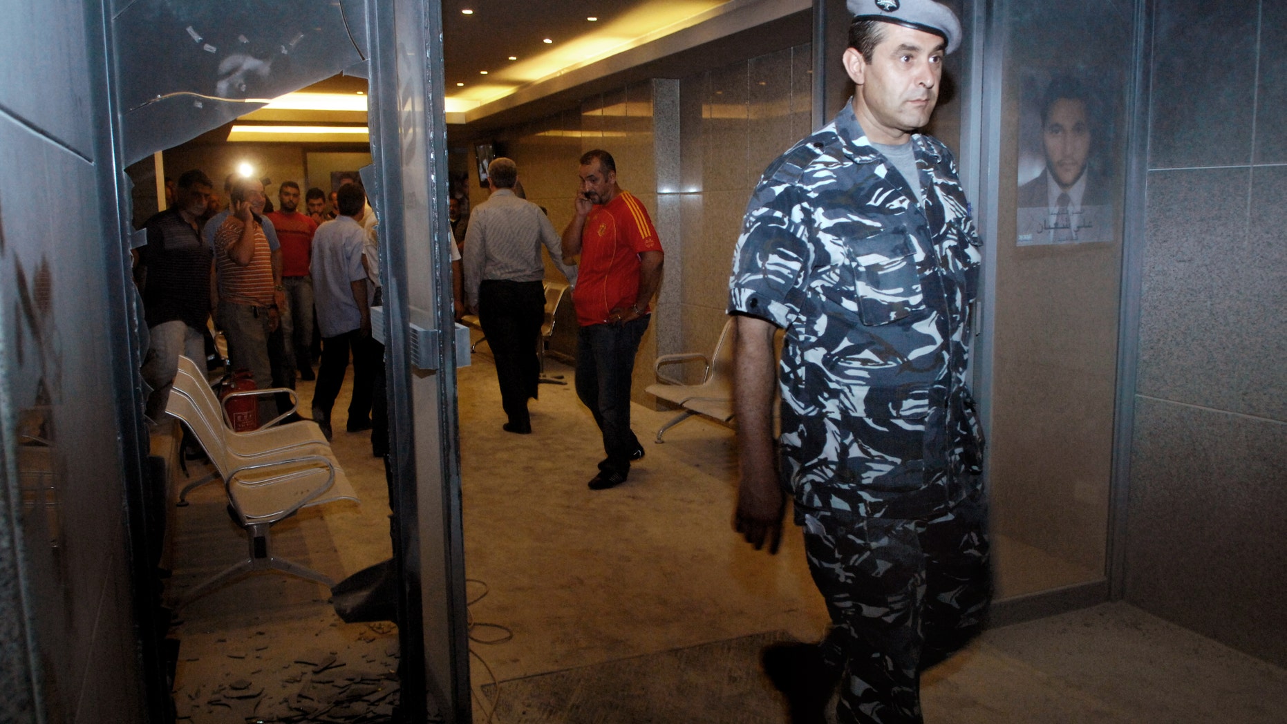 June 25, 2012: In this picture a Lebanese policeman steps out of the destroyed main entrance of the Lebanese TV station, in Beirut, Lebanon.