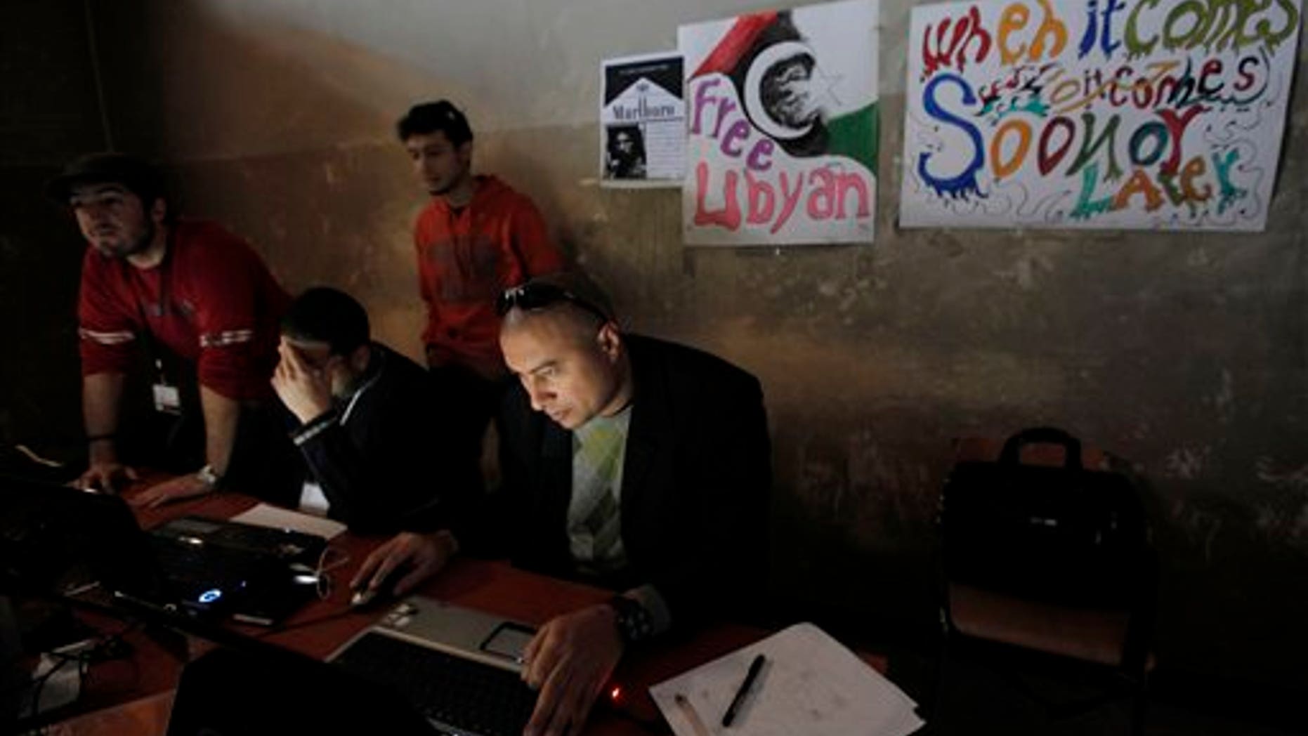 March 7:In this file photo, Libyan volunteers operate at the newly setup media center in what used to be a court house in Benghazi, Libya . The burnt-out building that once housed the high court has been transformed in the past three weeks into a bustling hub of civic life, home to a daily newspaper, a recording studio and a press center. (AP)