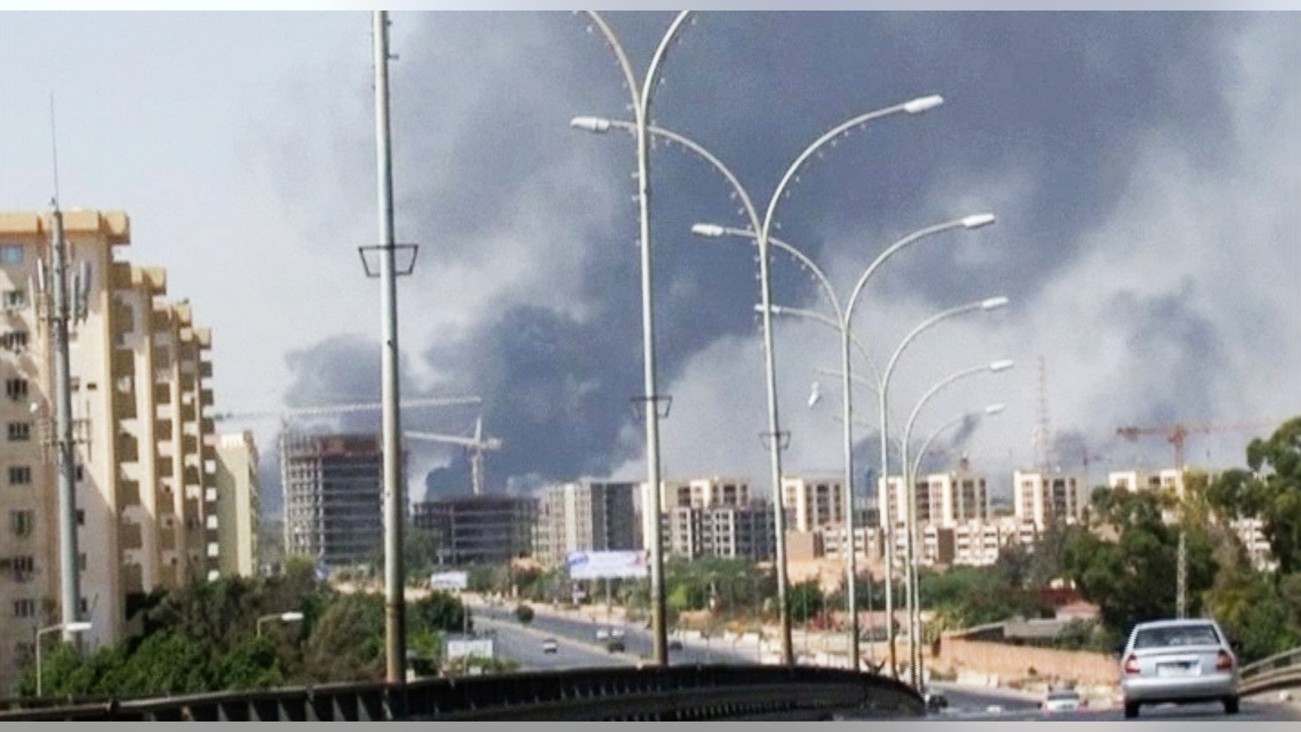 July 13, 2014 - Smoke rises from the direction of Tripoli airport in Libya. Rival militias battled for control of the international airport, as gunfire and explosions echoed through the city and airlines canceled some international flights.
