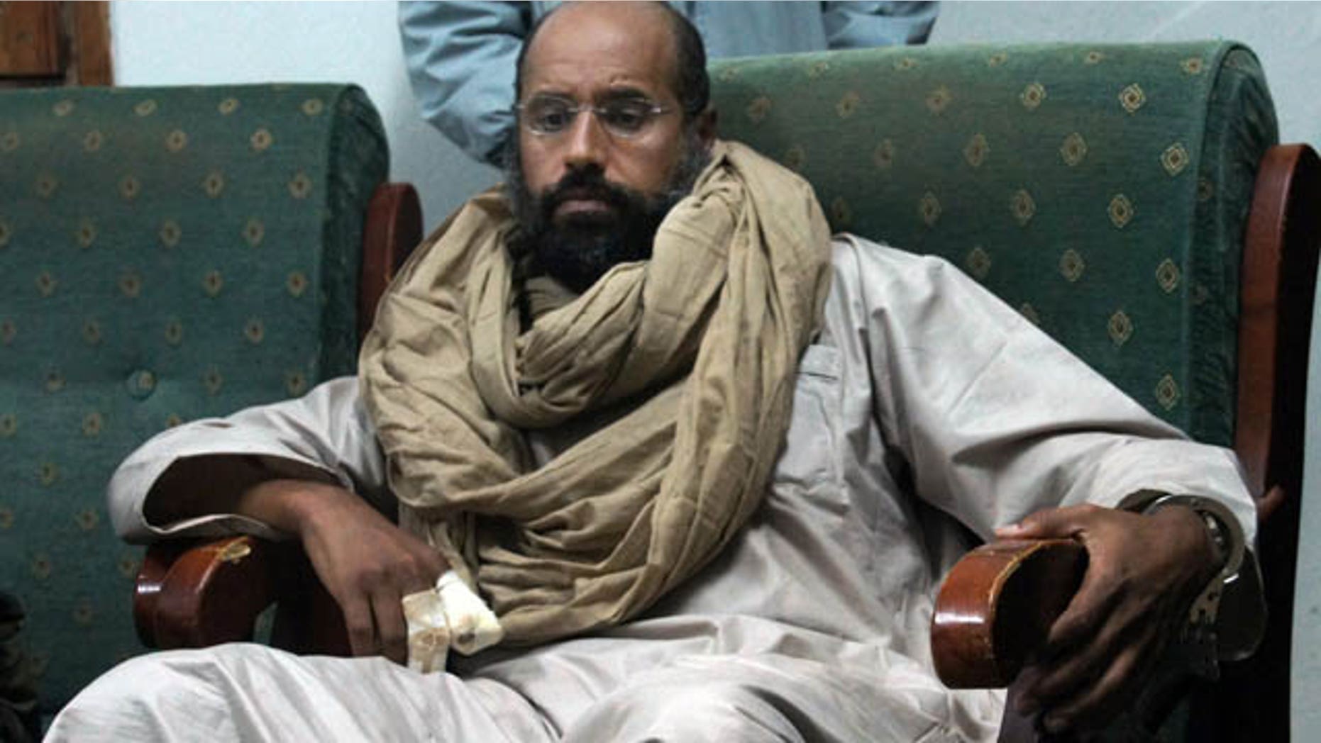 FILE - In this Saturday, Nov. 19, 2011 file photo, Seif al-Islam is seen after his capture in the custody of revolutionary fighters in Zintan. (AP Photo/Ammar El-Darwish, File)