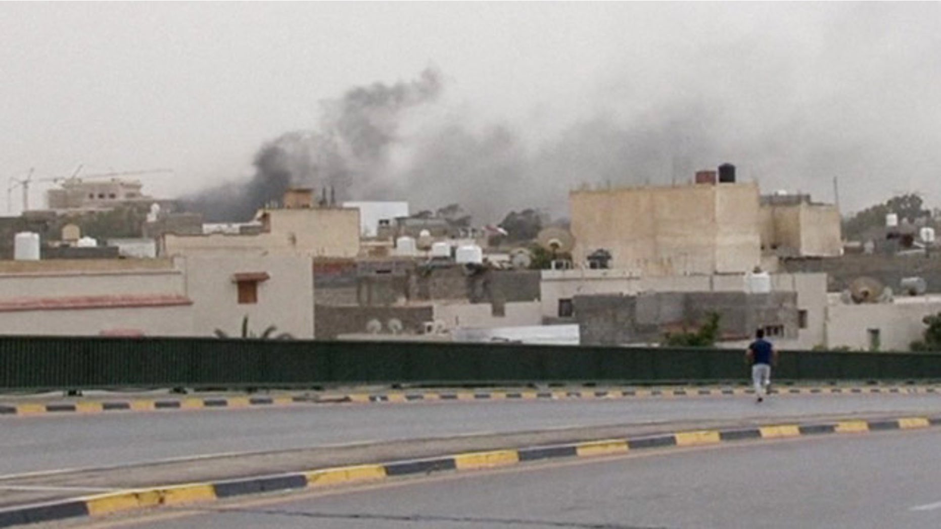 May 18, 2014: In this image made from video provided by the Libyan national army via AP Television, smoke rises over the parliament area after troops of Gen. Khalifa Hifter targeted Islamist lawmakers and officials at the parliament in Tripoli. (AP Photo/Libyan national army)